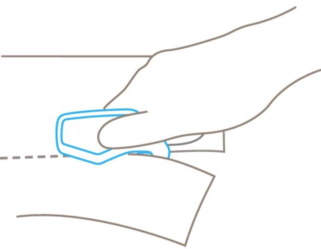 Eine Hand benutzt einen blauen Werkzeugscharfmarker, um Papier entlang einer gestrichelten Linie zu schneiden.