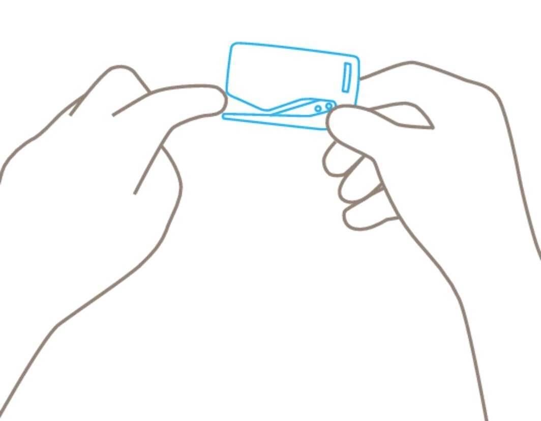 Zwei Hände halten eine sim-Karten-Trennhilfe. Eine Hand zeigt auf die Trennstelle der Karte.