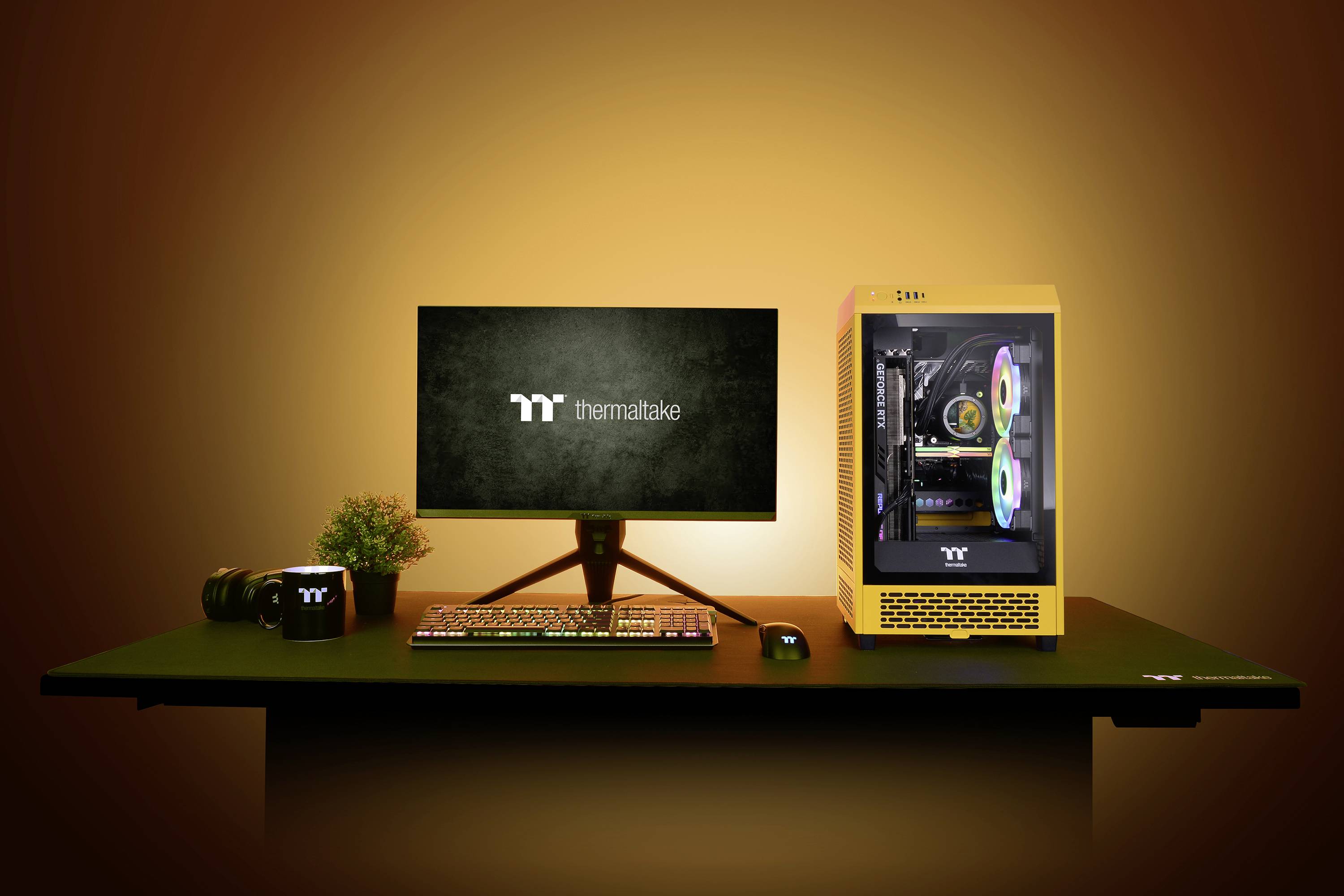 Schreibtisch mit computergesteuertem Monitor, gelbem PC-Gehäuse mit leuchtenden Lüftern und Tastatur, dekorativ beleuchtet.