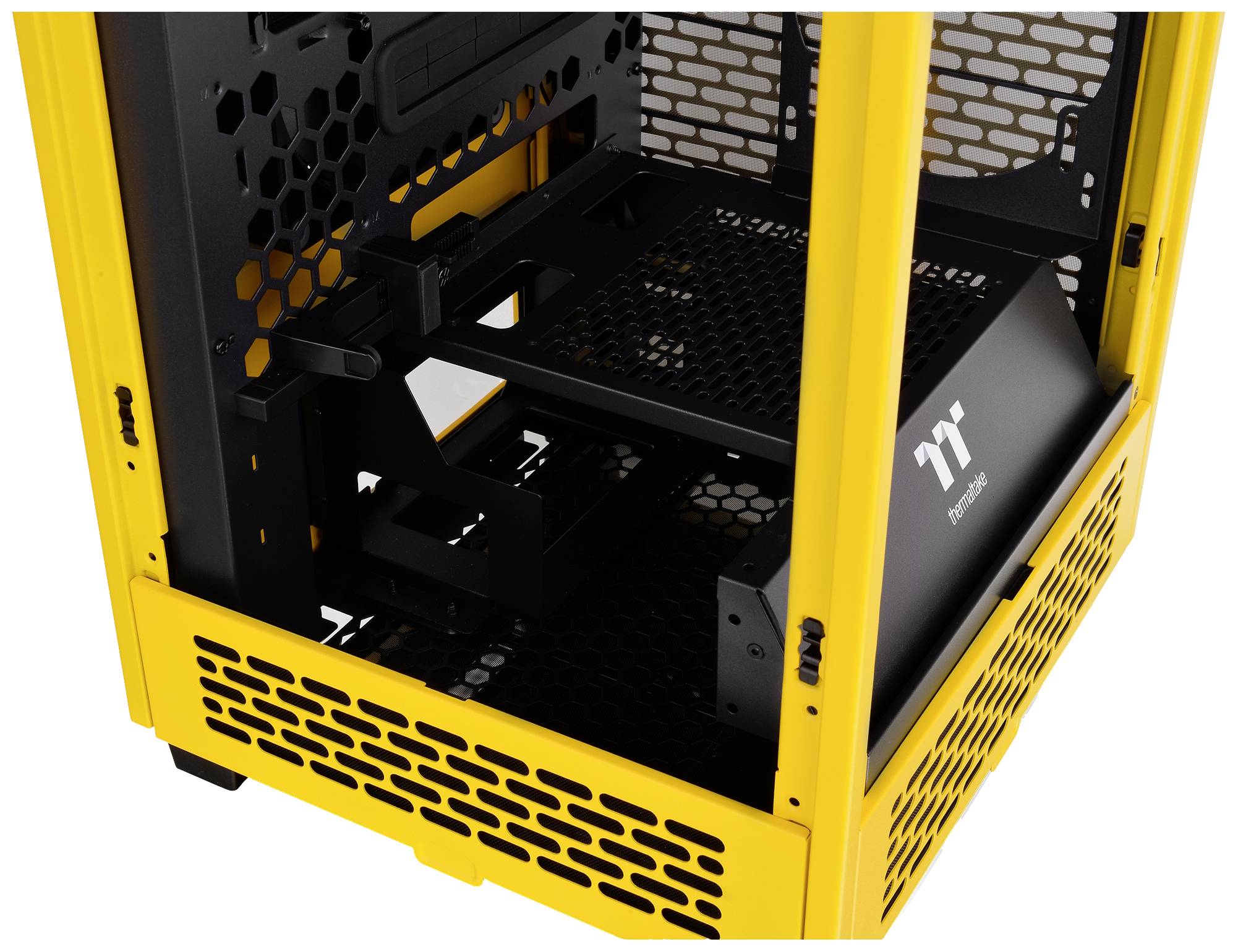 Ein gelbes Computergehäuse mit schwarzem Gitterdesign, geöffnet, zeigt das Innere. Enthält Platz für Komponenten und Belüftung.
