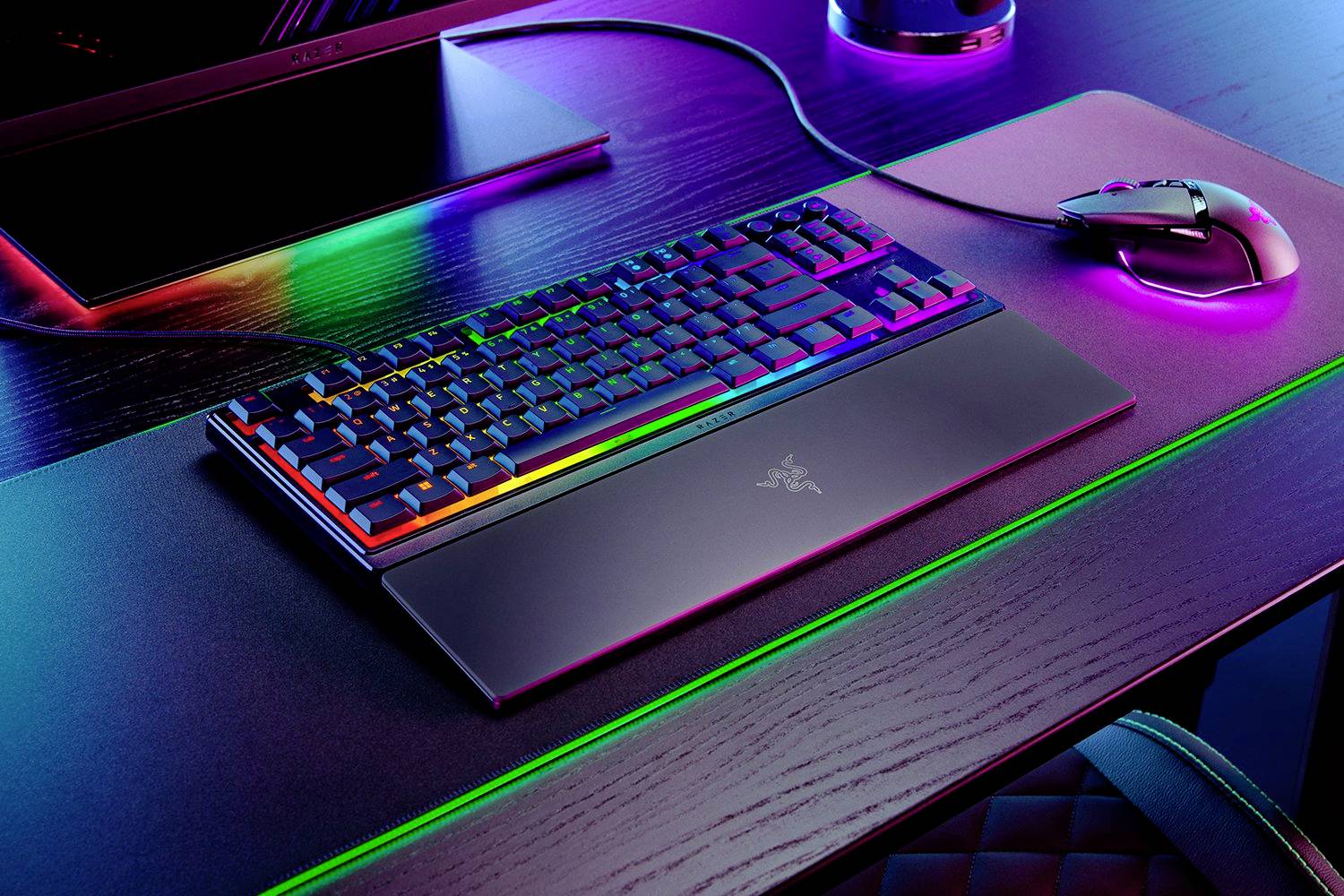Eine Gaming-Tastatur und -Maus auf einem Schreibtisch, beide mit RGB-Beleuchtung, die in verschiedenen Farben leuchtet.