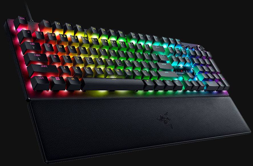 Mechanische Tastatur mit RGB-Beleuchtung auf schwarzem Hintergrund. Tasten leuchten in verschiedenen Farben und zeigen lebendige Muster.
