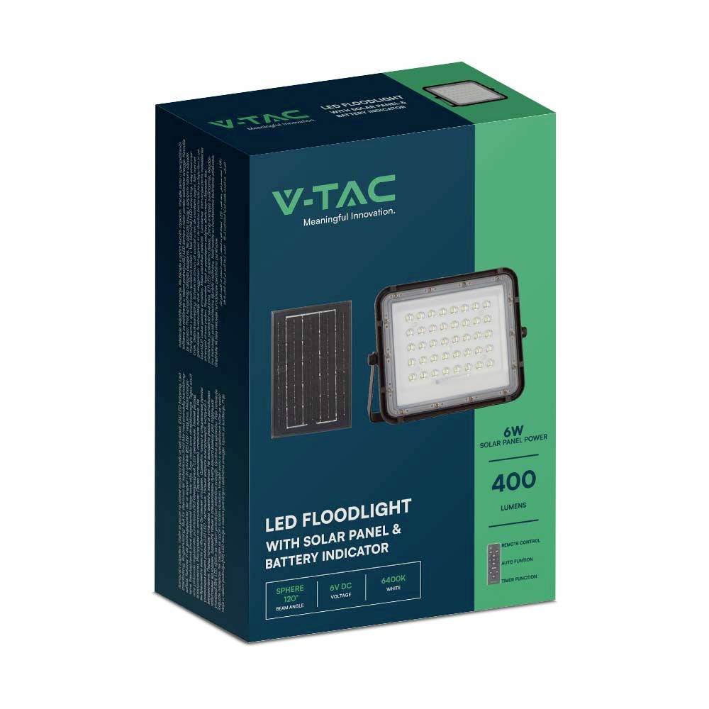 Eine Verpackung zeigt einen LED-Flutlichtstrahler mit Solarpanel und Batteriestatusanzeige. Details: 6W, 400 Lumen, wasserfest, dunkelgrüne Box.