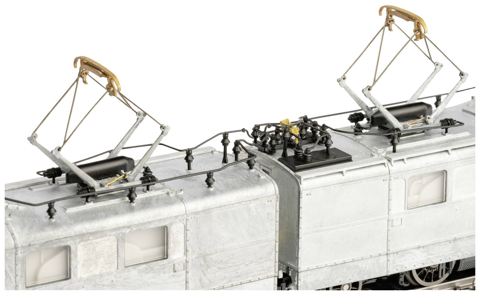 Eine silberne Elektrolokomotive mit zwei Stromabnehmern auf dem Dach. Die Lok hat viele Details und ist über Schienen verbunden.