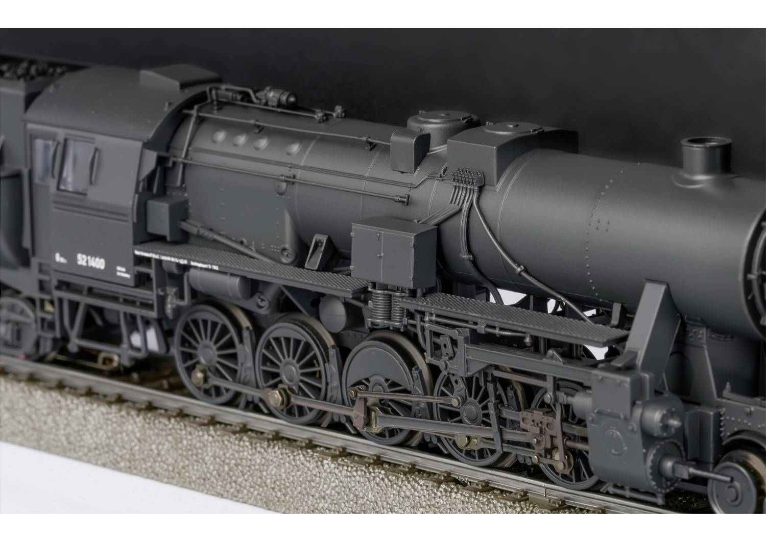 Eine detaillierte Modell-Eisenbahn-Dampflokomotive aus der Nähe, schwarz, mit sichtbaren Rädern und komplexen mechanischen Teilen.