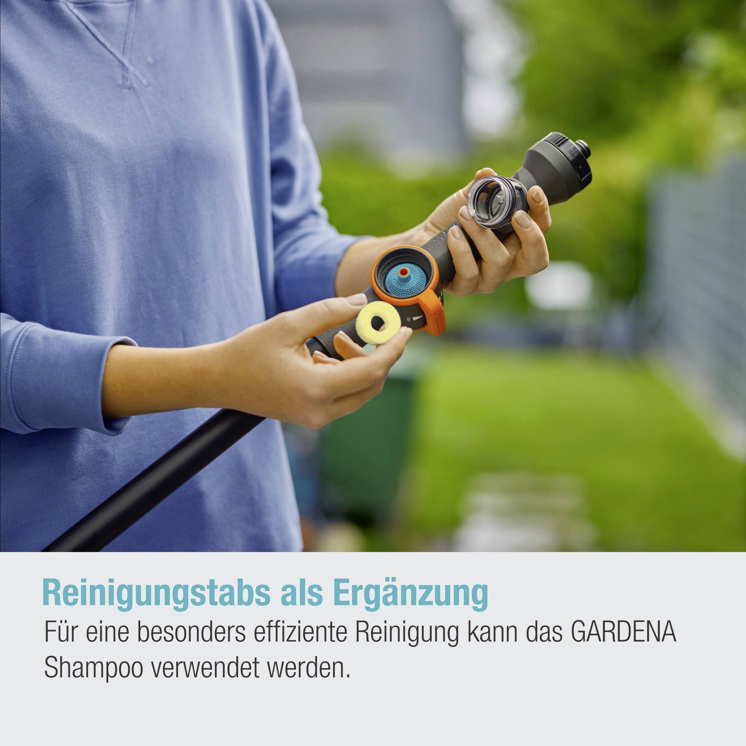 Eine Person hält ein Schlauchende mit verschiedenen Reinigungstabs. Text: 'Reinigungstabs als Ergänzung'. Umgebung ist unscharf.