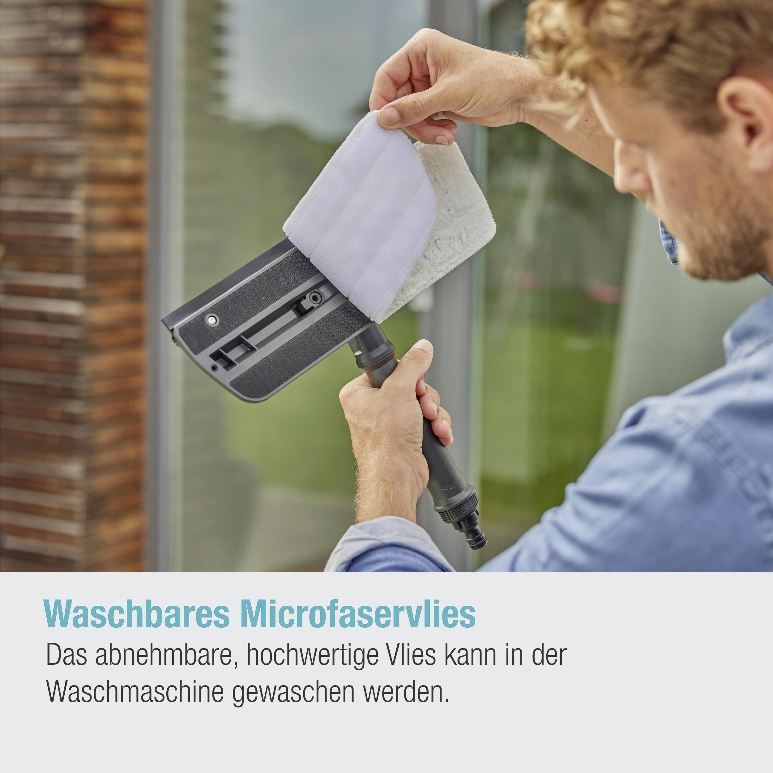 Person reinigt Düse eines Staubsaugers mit abnehmbarem, waschbarem Vlies. Beschriftung hebt Waschbarkeit in der Maschine hervor.