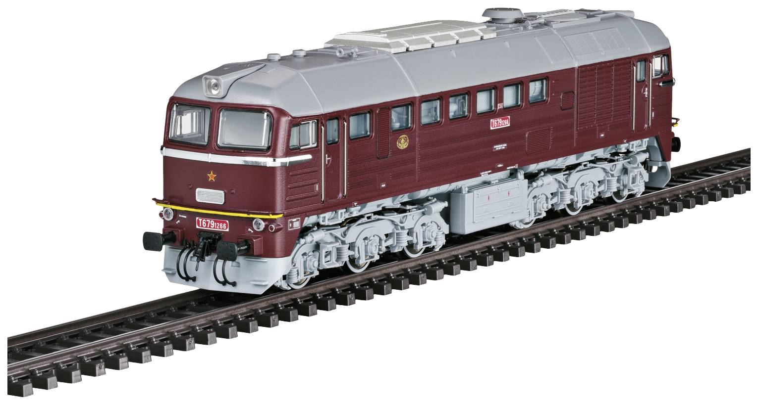 Eine Modelllokomotive in roter und grauer Farbe fährt auf einem Eisenbahngleis. Sie hat Details wie Fenster und Räder im Miniaturformat.