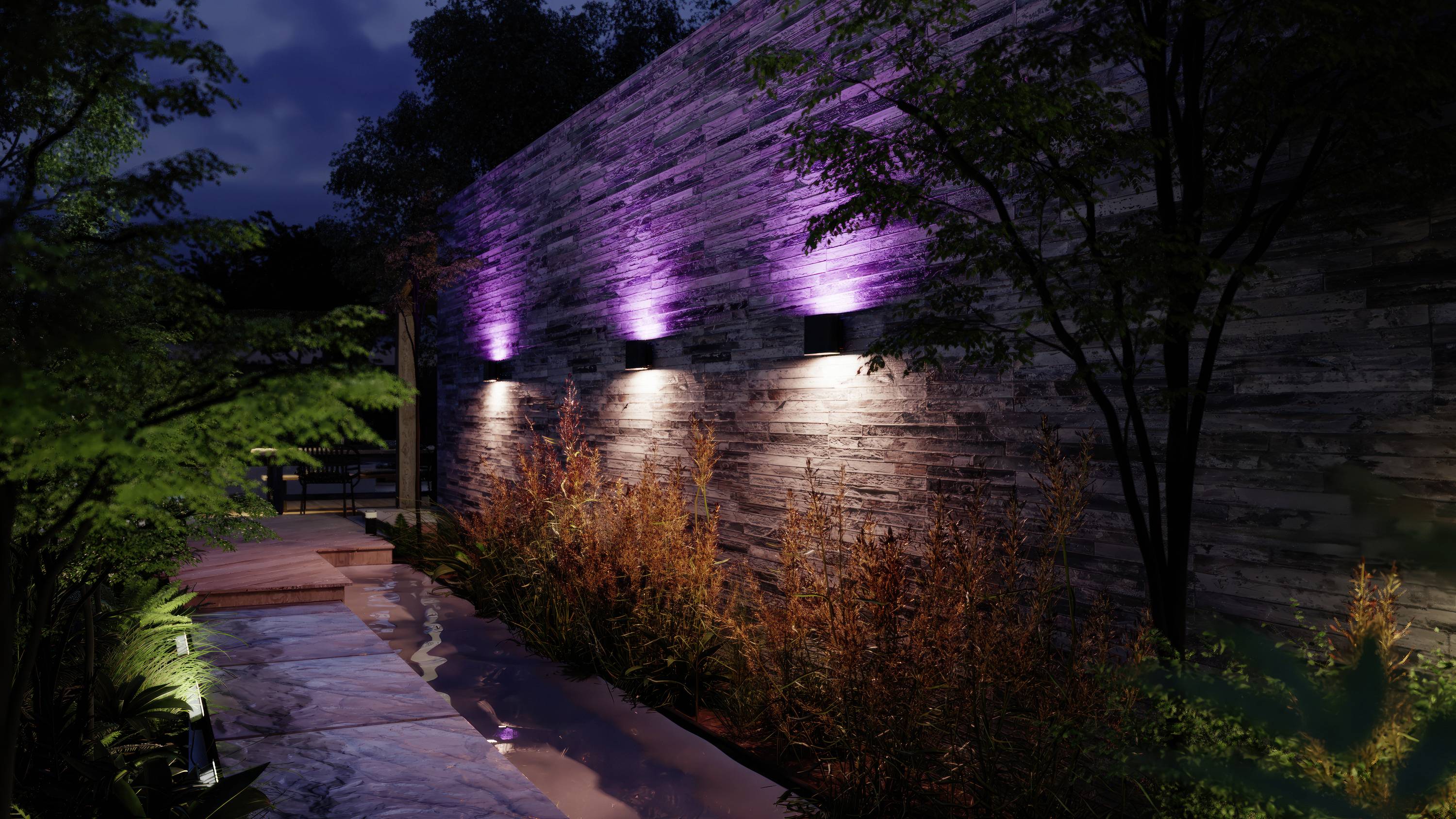 Gartenweg bei Nacht mit lila beleuchteter Steinmauer, flankiert von Bäumen und Pflanzen, die eine ruhige und stimmungsvolle Atmosphäre schaffen.