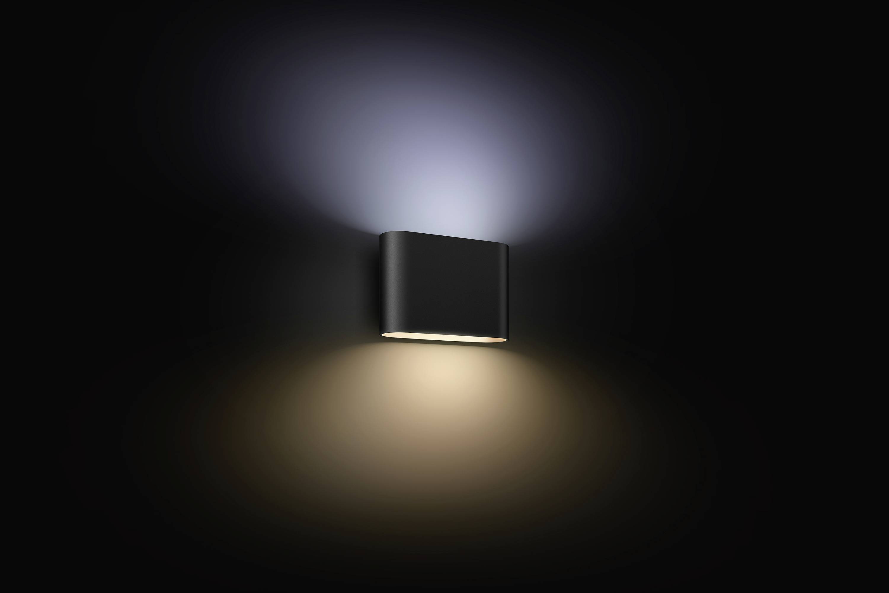 Wandleuchte leuchtet nach oben und unten, erzeugt weiches, diffuses Licht auf einer dunklen Wand. Minimalistisches Design.