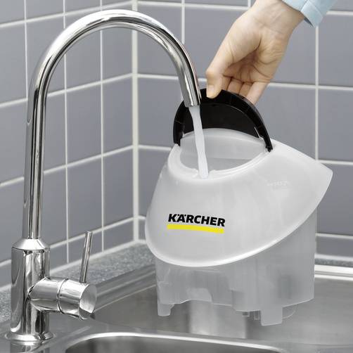 Eine Hand hält einen Kärcher-Wassertank unter einen Wasserhahn zum Befüllen. Der Wasserhahn befindet sich in einer Küche vor blauen Kacheln.