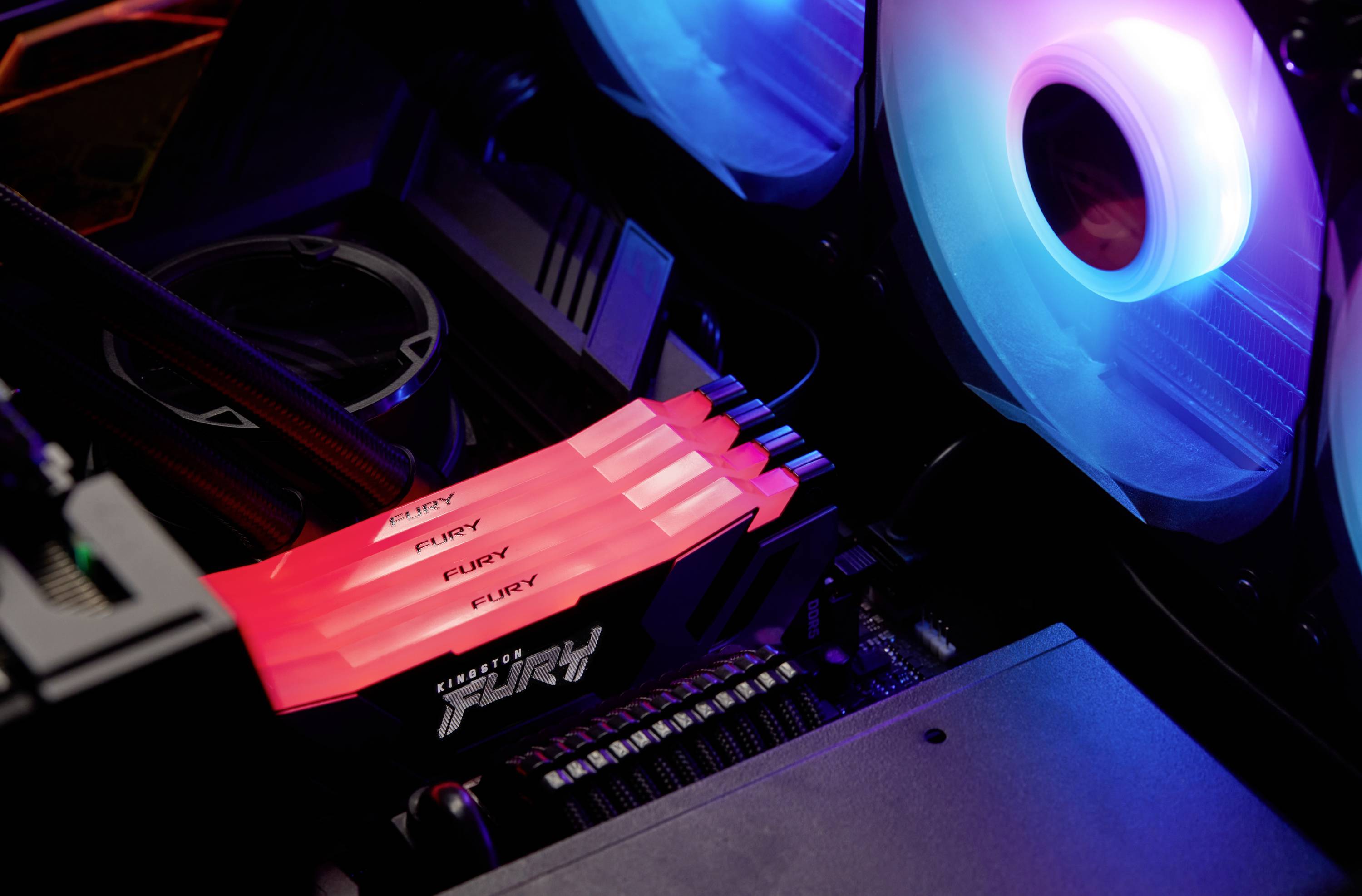 Leuchtende LED-Lüfter und RAM mit der Aufschrift 'Fury' in einem offenen Computergehäuse, betonen die Gaming-Ästhetik.