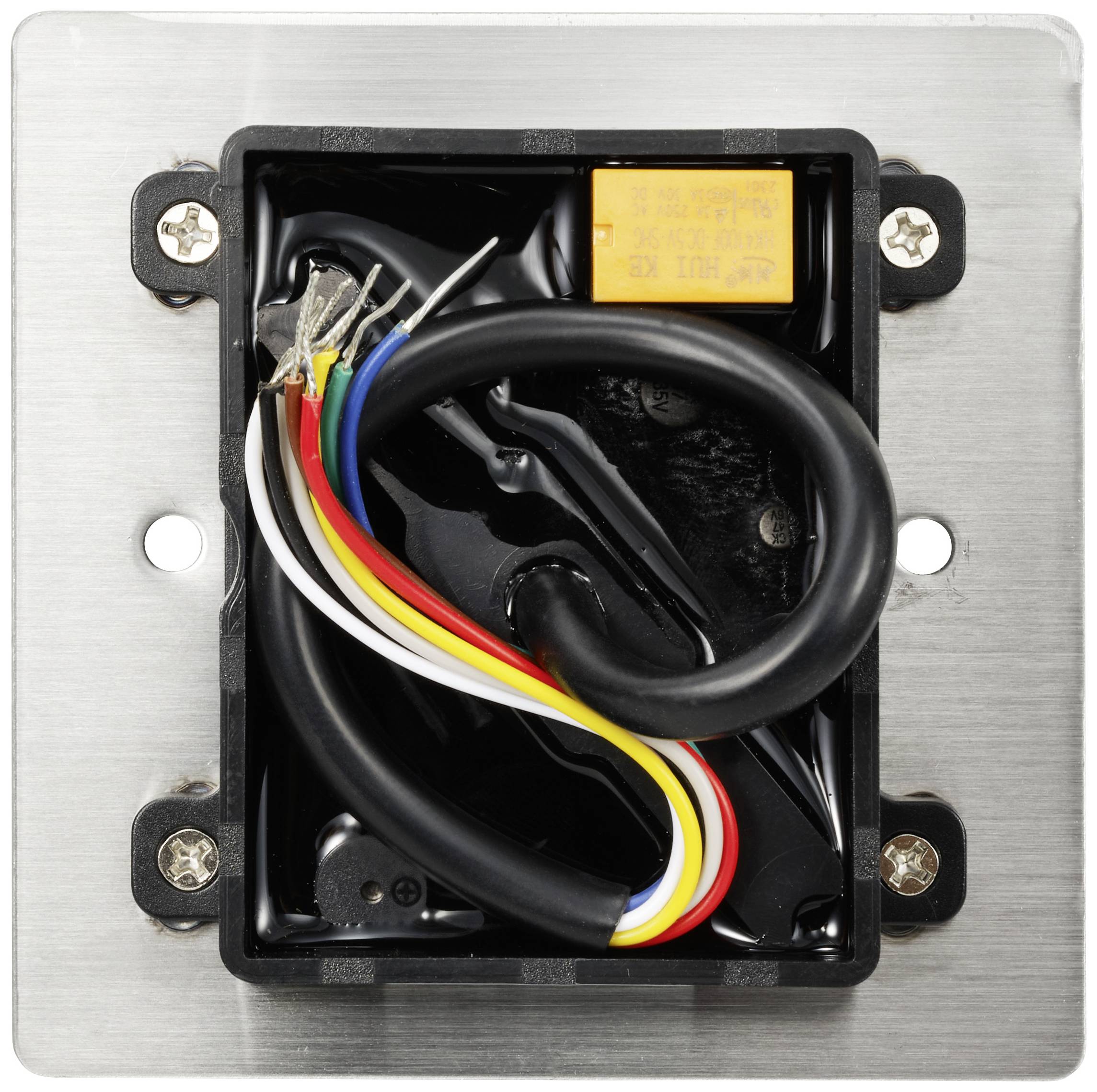 Ein offenes elektrisches Wandanschlussfeld mit mehreren farbigen Drähten und einem kleinen gelben Bauteil auf einer Metallplatte.