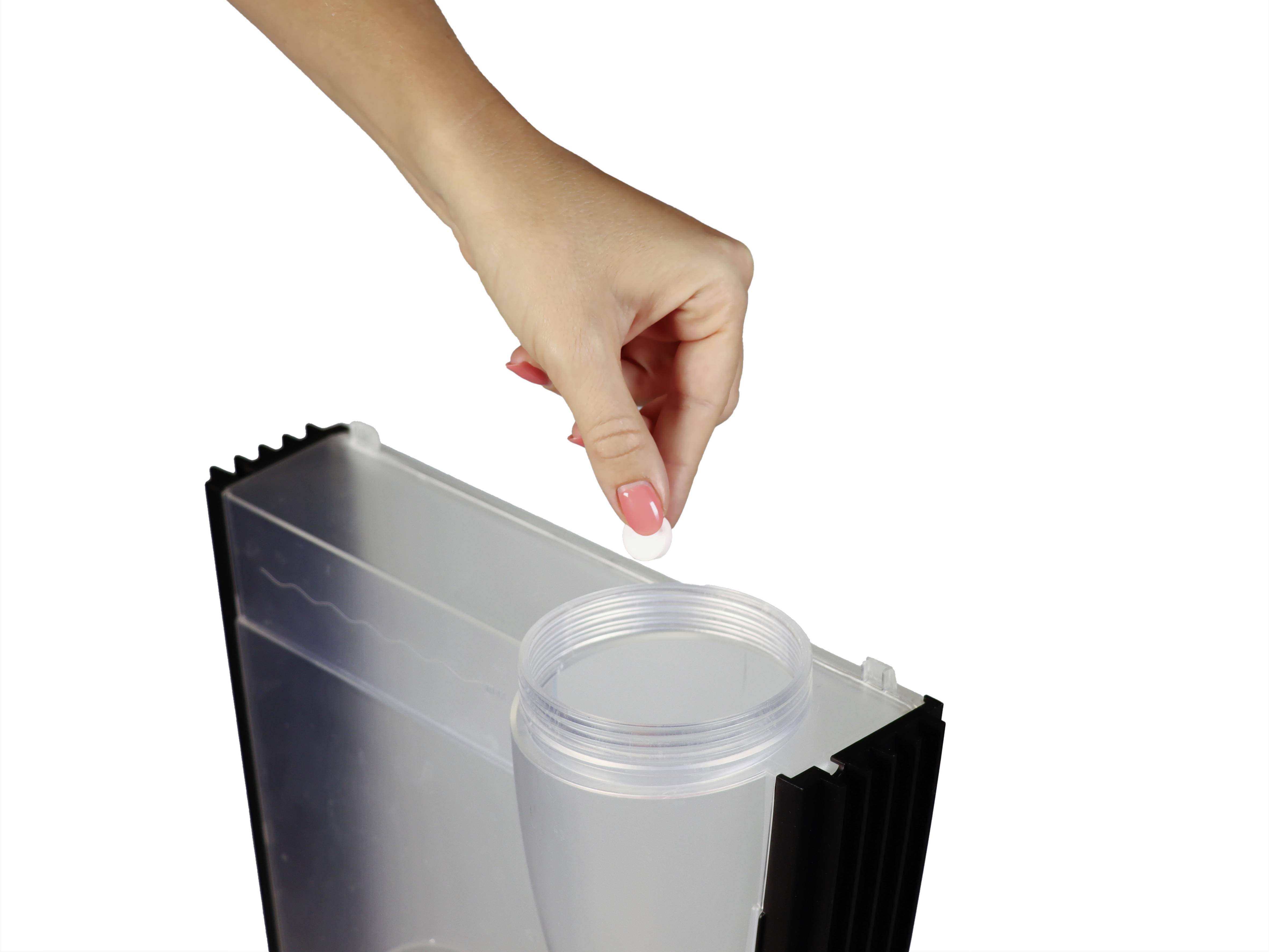 Eine Hand hält eine Tablette über einen großen Wasserfilterbehälter, bereit zum Einlegen.