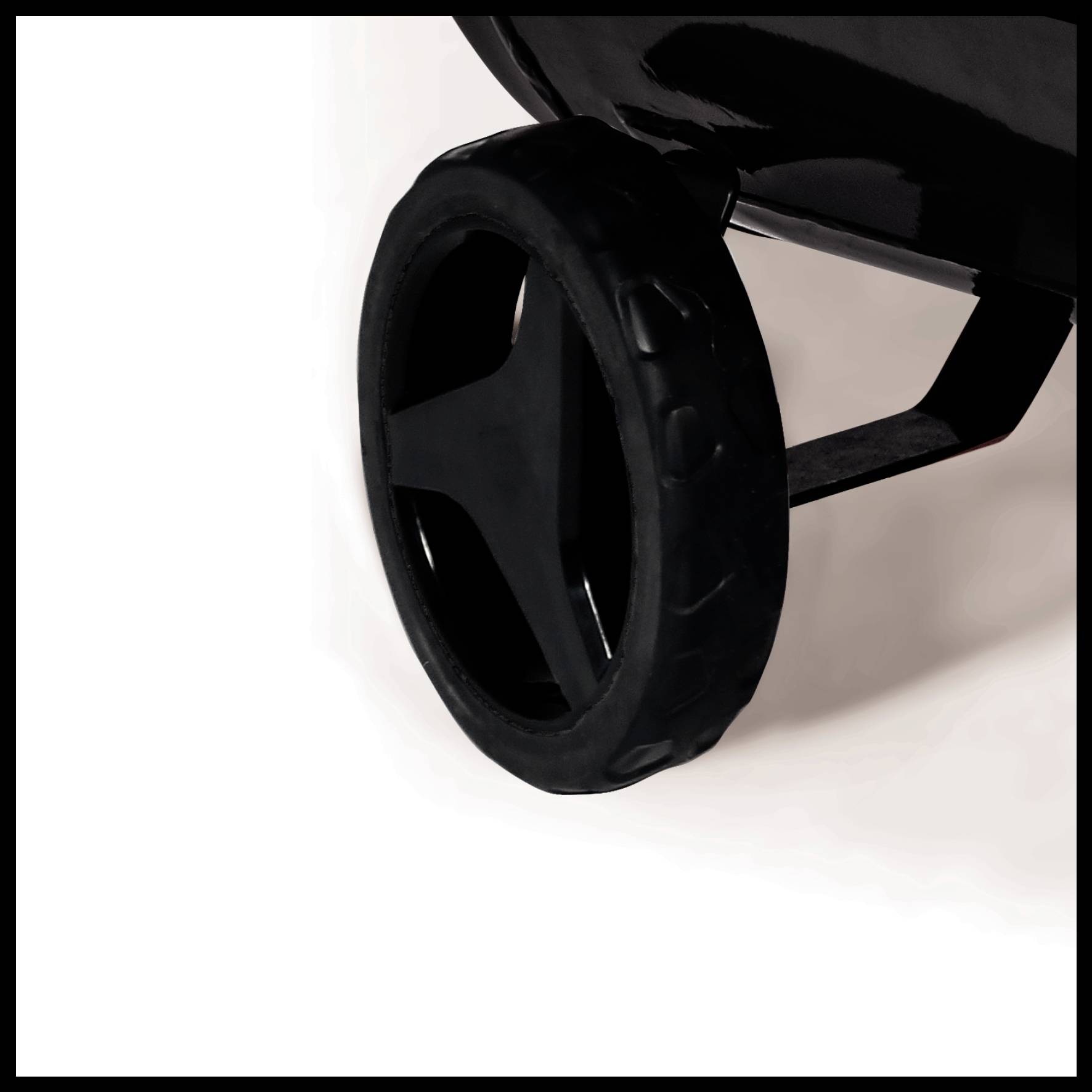 Ein schwarzes Rad, Teil eines größeren Gegenstands, auf weißem Hintergrund. Es scheint zu einem Gerät oder Fahrzeug zu gehören.