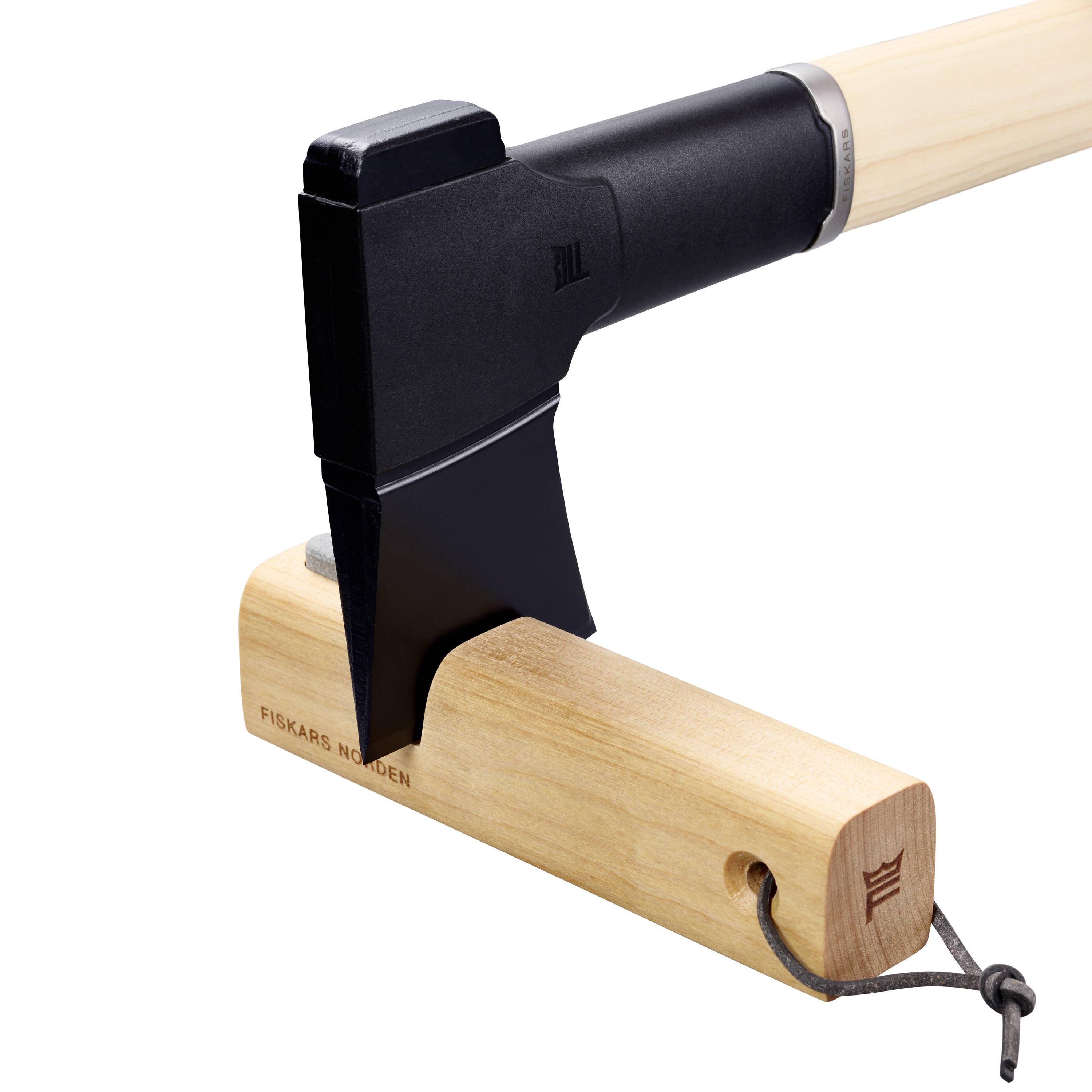 Eine Axt mit schwarzem Kopf und hellem Holzgriff. Die Klinge ist in den Holzblock eingeschlagen. Markiert mit 'Fiskars Norden'.