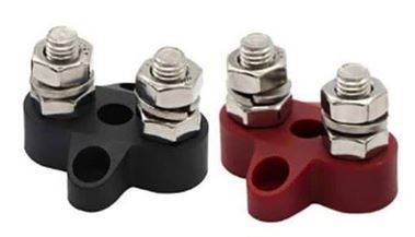 Zwei Kabelklemmen, eine schwarz und eine rot, mit jeweils zwei Schraubanschlüssen. Verwendet zur elektrischen Verdrahtung.