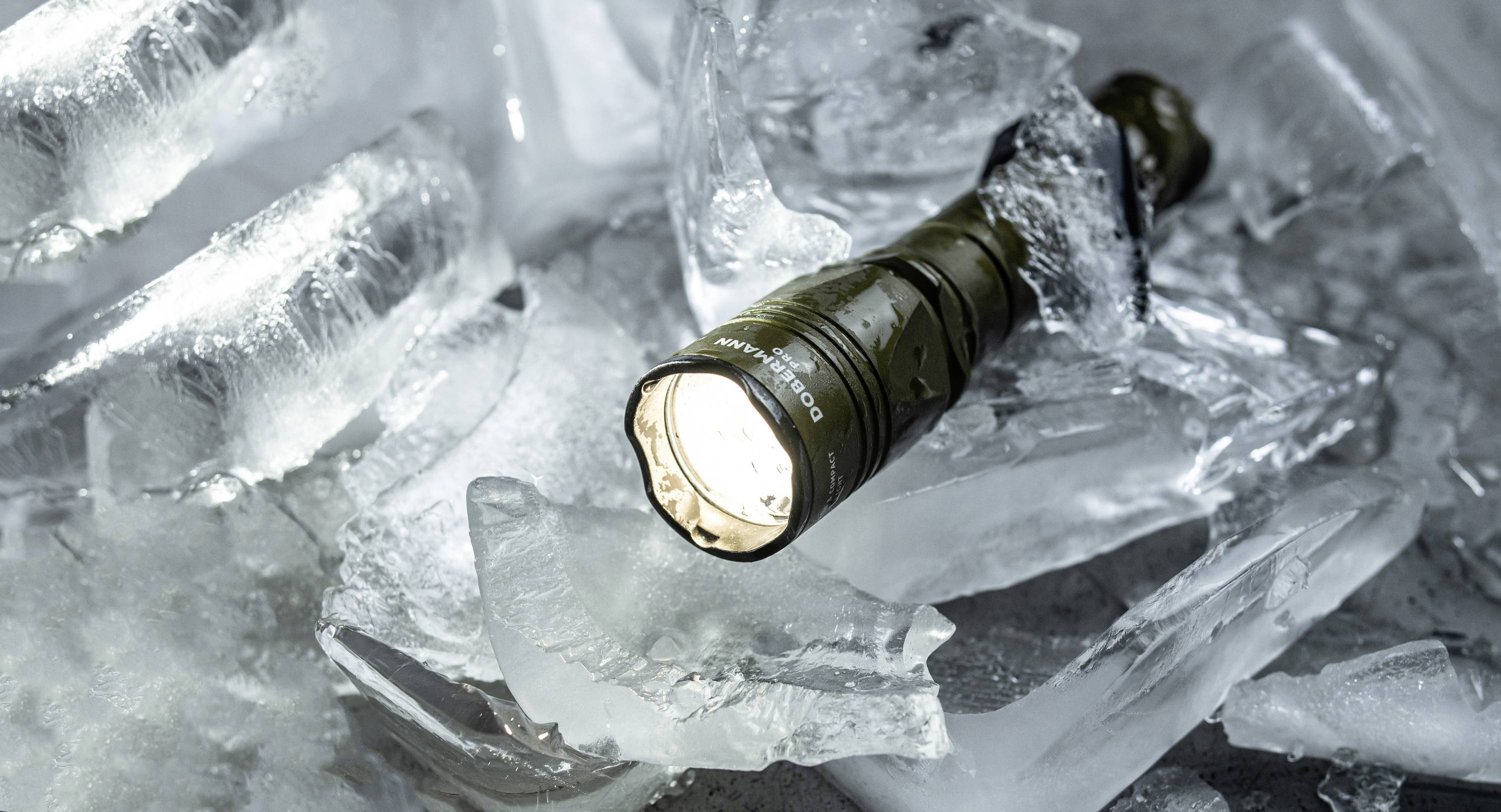 Eine eingeschaltete Taschenlampe liegt auf zerbrochenen Eisstücken und beleuchtet die Umgebung.