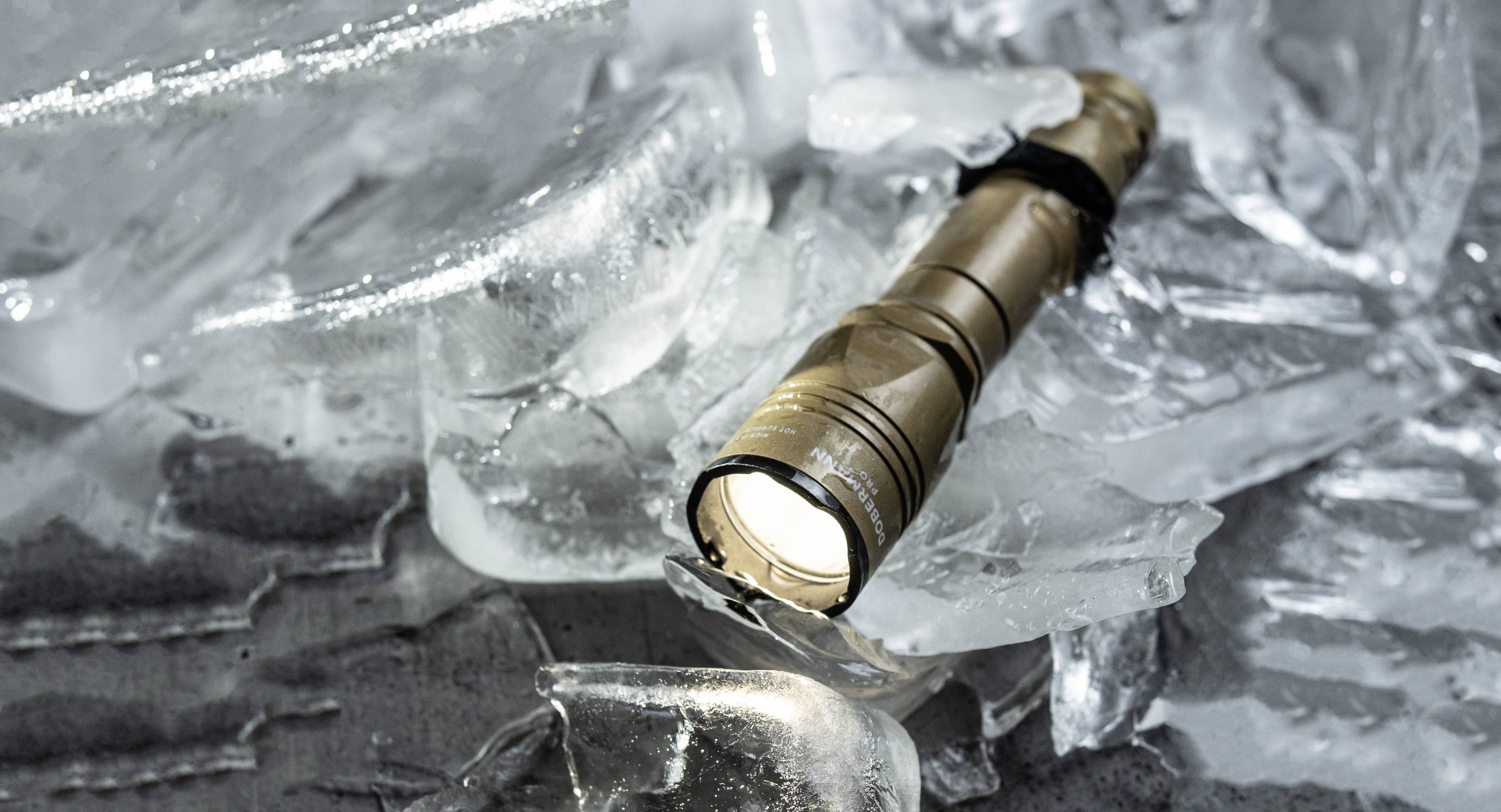 Taschenlampe liegt auf zerbrochenem Eis, strahlt Licht aus.