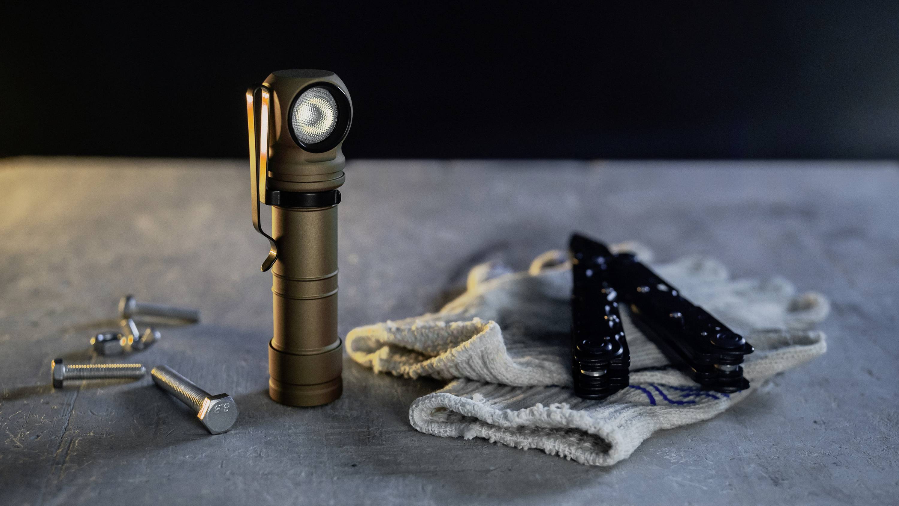 Eine Taschenlampe steht auf einem Tisch neben einem Handtuch und Werkzeugen.
