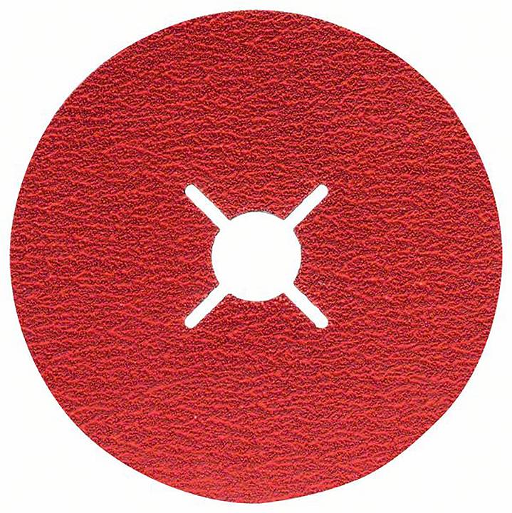 Runde, rote Schleifscheibe mit einer kreuzförmigen Öffnung in der Mitte, auf rauer Oberfläche.