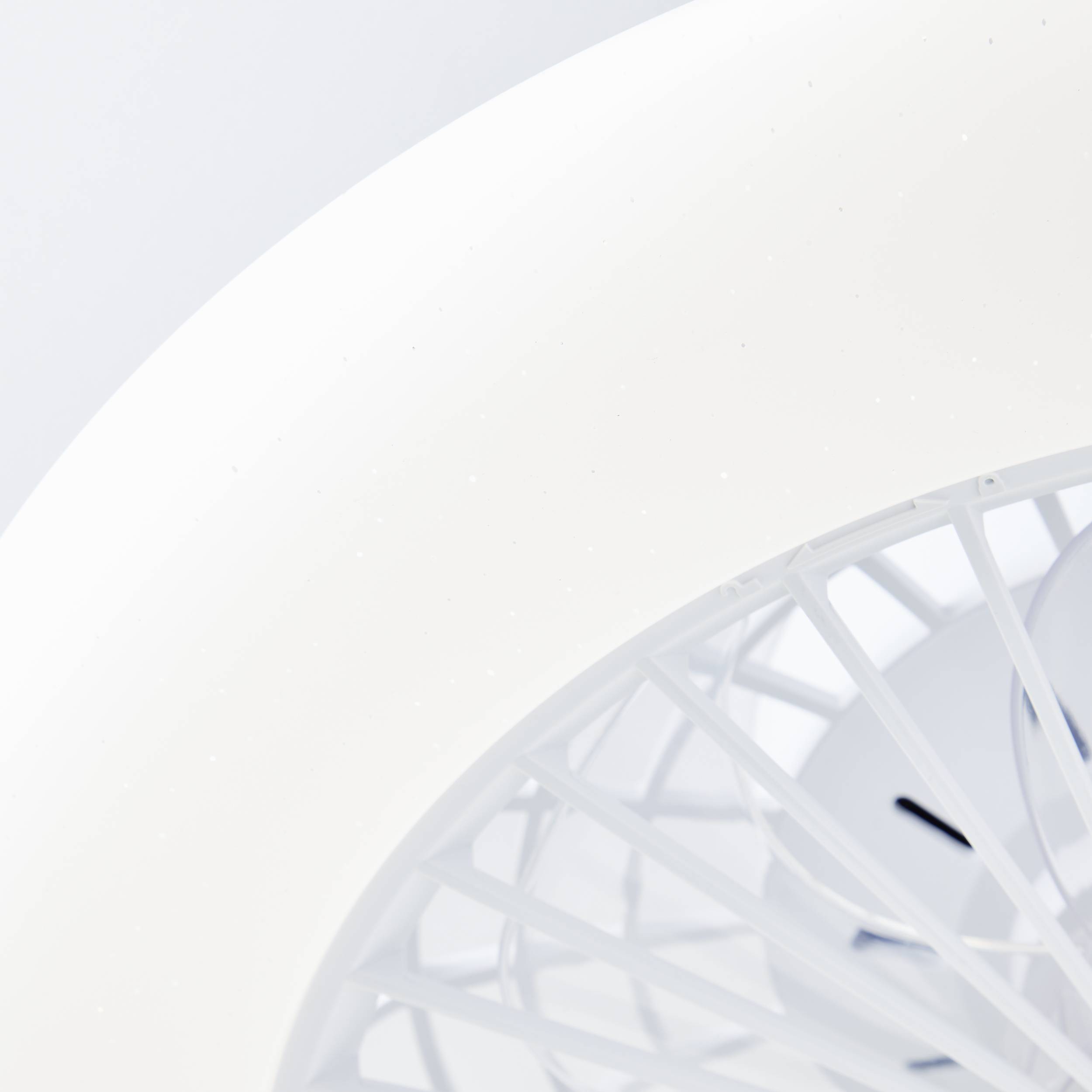 Eine Nahaufnahme eines weißen Ventilators. Die Gitterstruktur und die Klingen sind sichtbar. Der Hintergrund ist ebenfalls weiß.