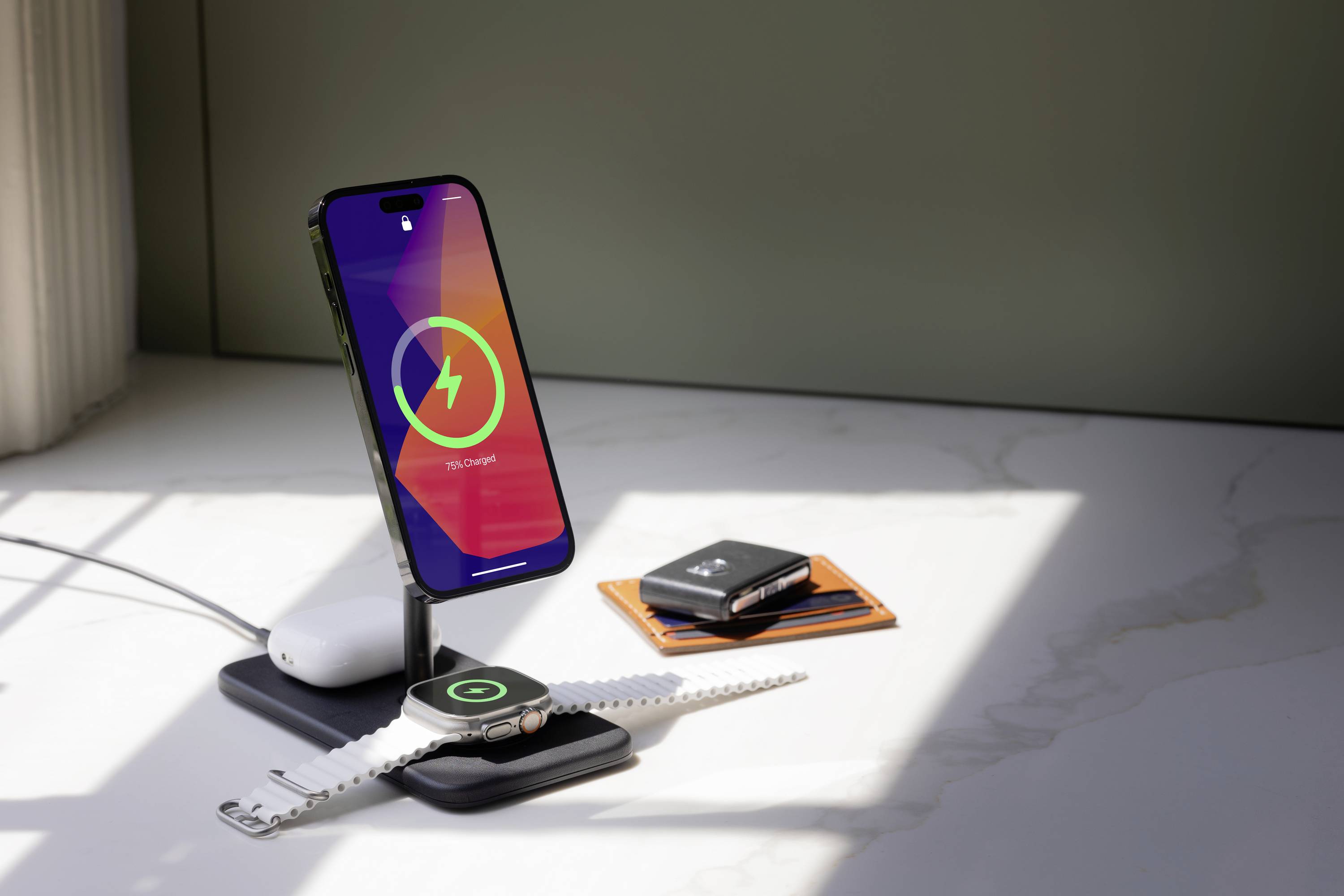 Stromversorgung mehrerer Geräte: Smartphone, Smartwatch und Kopfhörer werden auf einer kabellosen Ladestation aufgeladen.