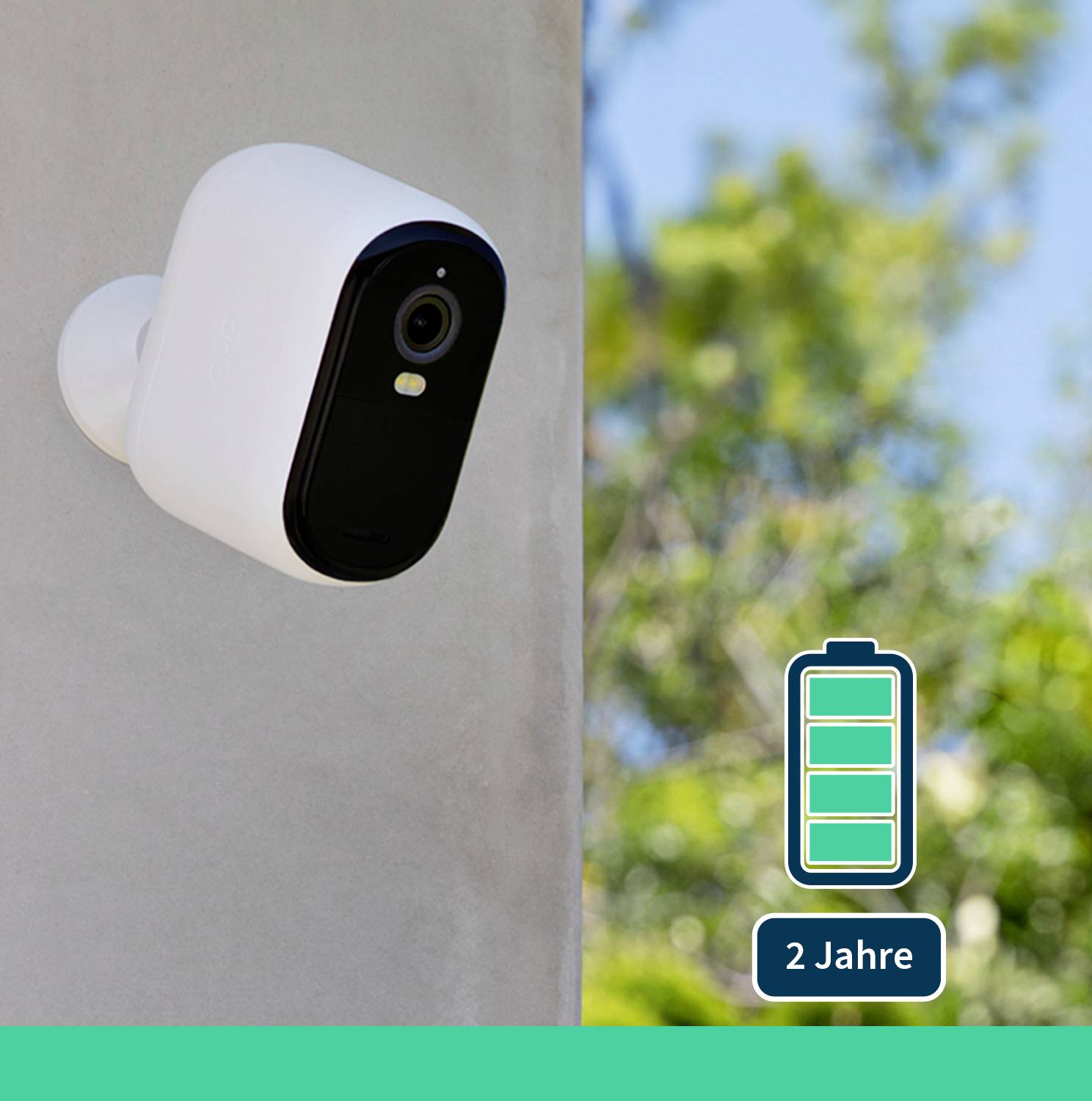 Überwachungskamera an der Wand mit Symbol für eine Batterie und Hinweis '2 Jahre', im Außenbereich bei sonnigem Wetter.
