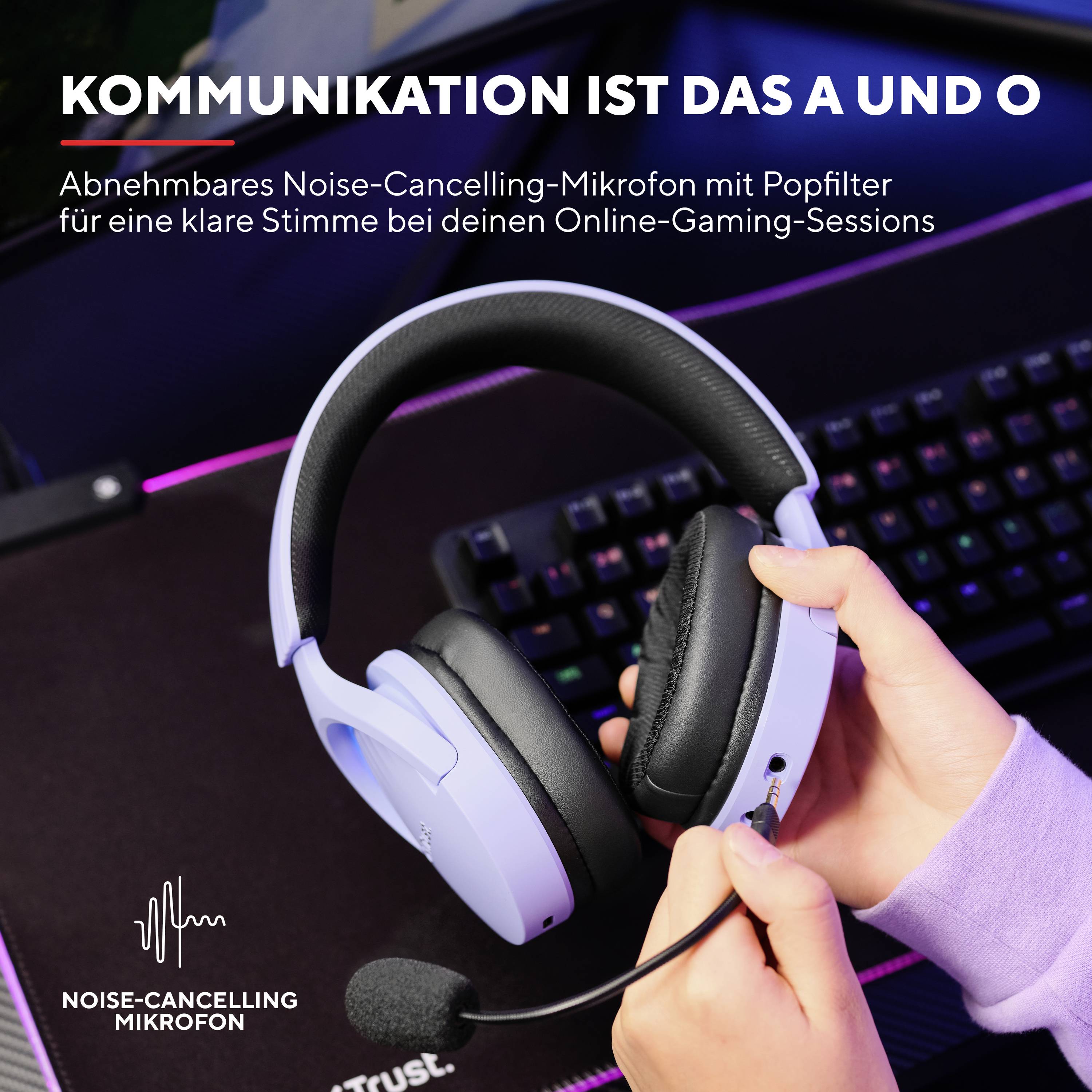 Das Bild zeigt ein lila Headset mit Noise-Cancelling, das in einer Hand gehalten wird. Im Hintergrund ist die Tastatur eines Computers zu sehen. Oben steht: 'Kommunikation ist das A und O'.