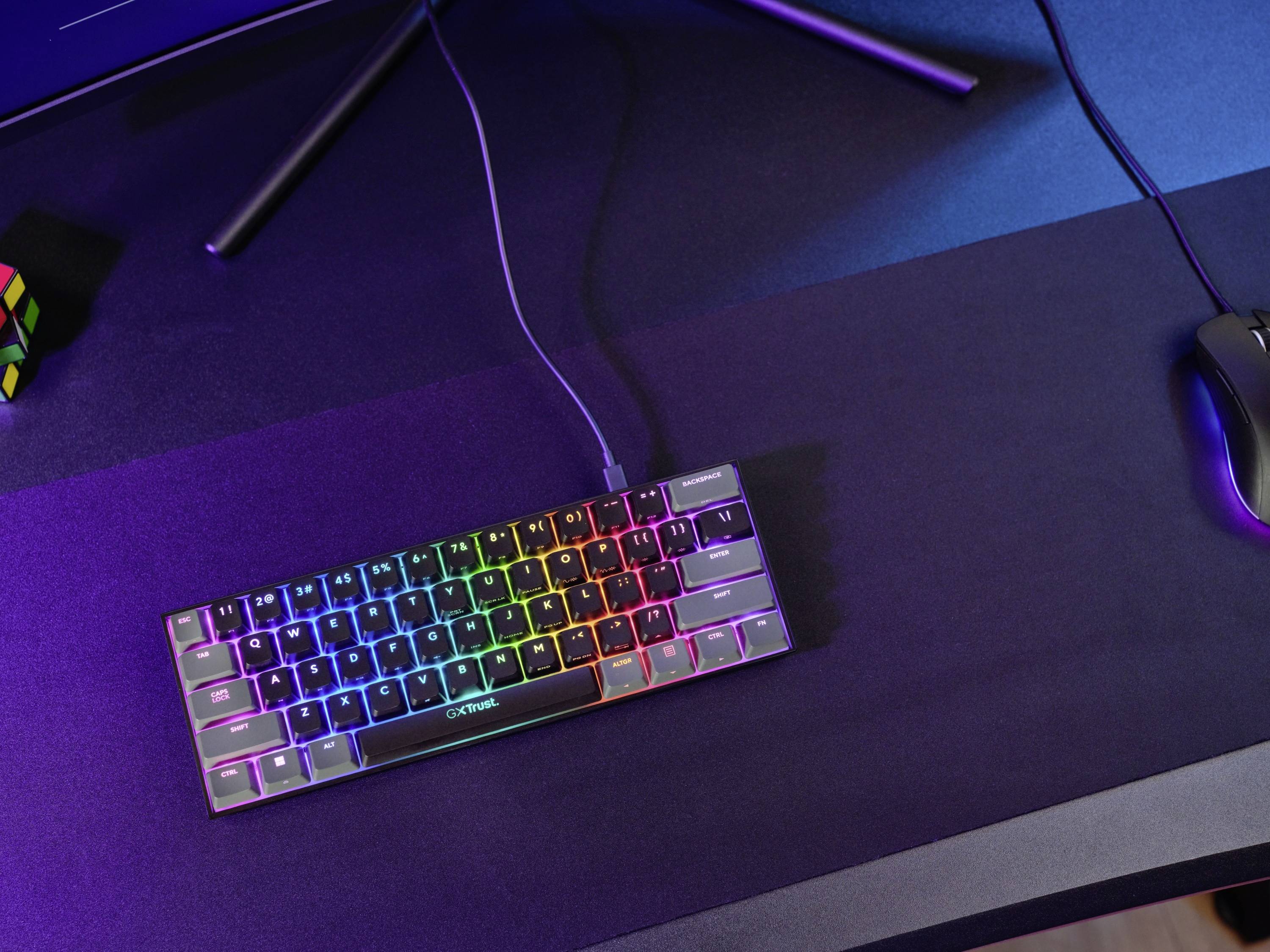 Mechanische Tastatur mit RGB-Beleuchtung auf einem Schreibtisch, daneben eine Computermaus und ein Rubik's Cube.