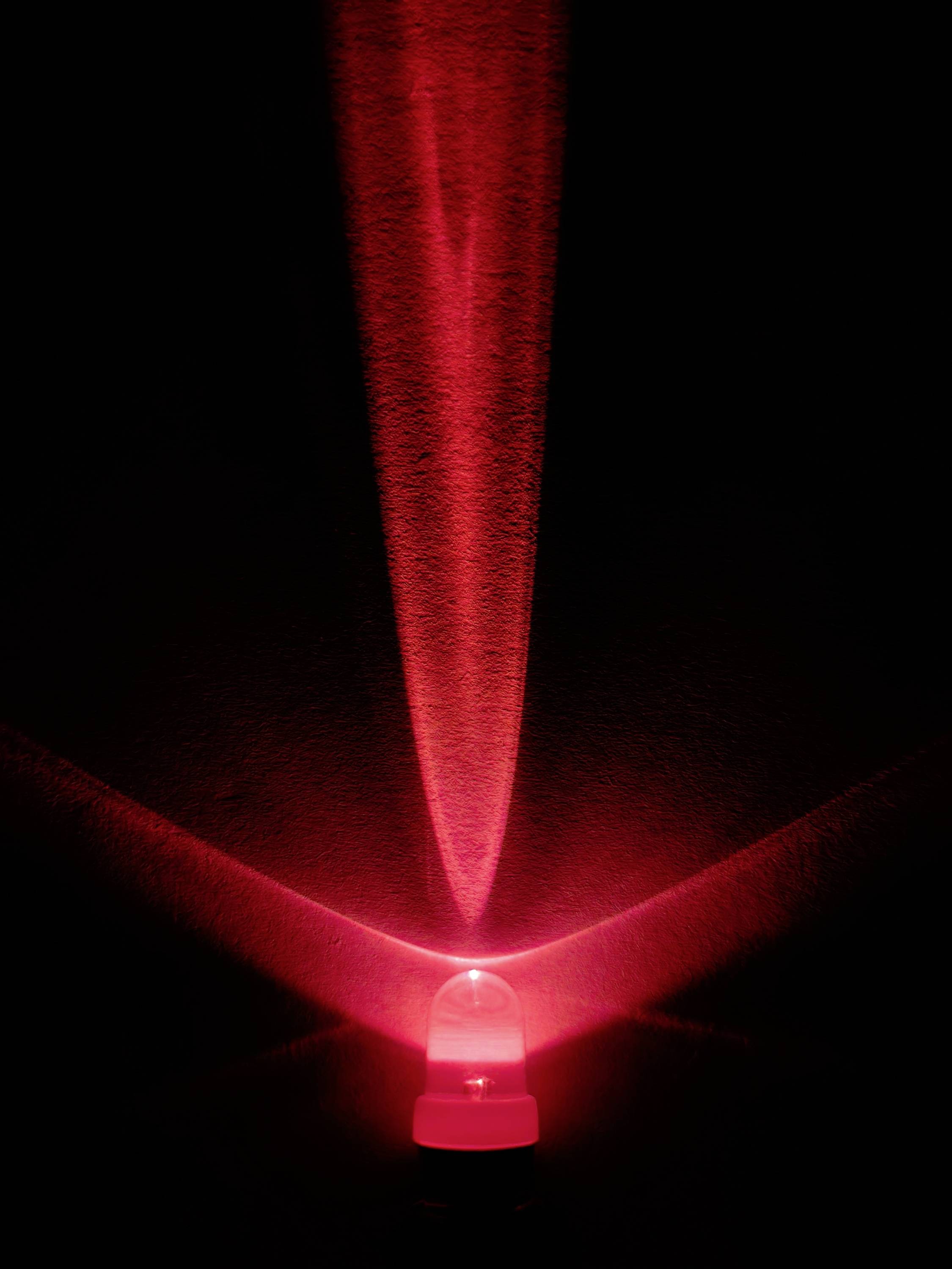 Leuchtende rote LED in der Dunkelheit, strahlt V-förmiges Lichtmuster auf schwarze Oberfläche.