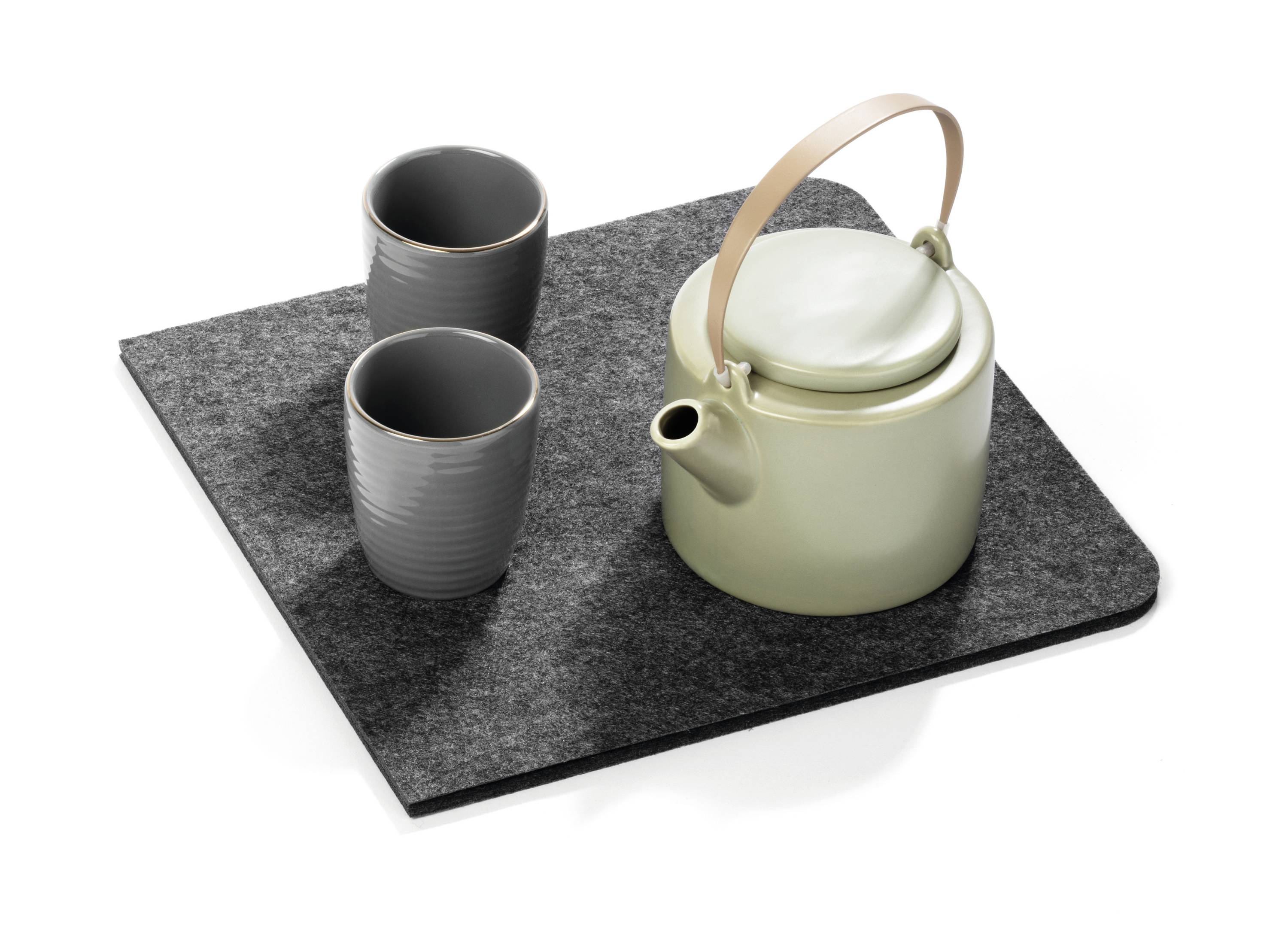 Grüner Teekessel mit Holzgriff und zwei grauen Teebechern auf einem grauen Filzuntersetzer.