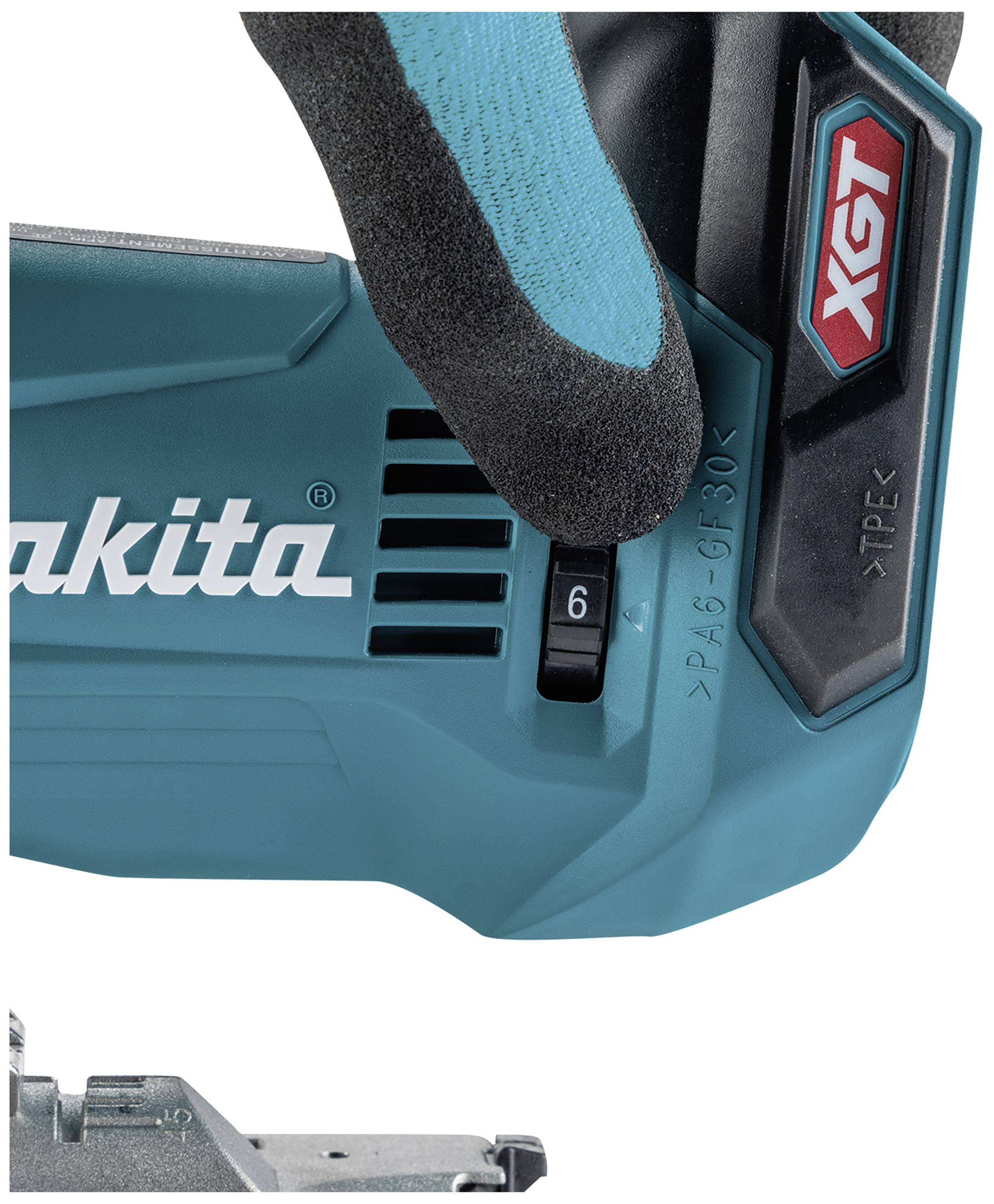 Ein Elektrowerkzeug in türkis mit schwarzem Griff, teils von einer behandschuhten Hand gehalten. Aufschrift: 'Makita' und 'XGT'.
