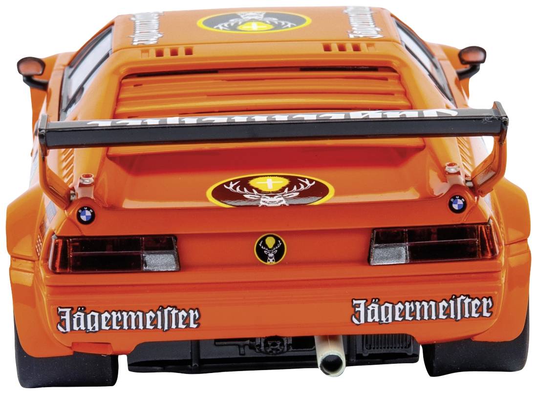 Ein orangefarbenes Sportauto mit Jägermeister-Logo steht von hinten sichtbar, gut zu sehen ist der Heckspoiler und der Auspuff.