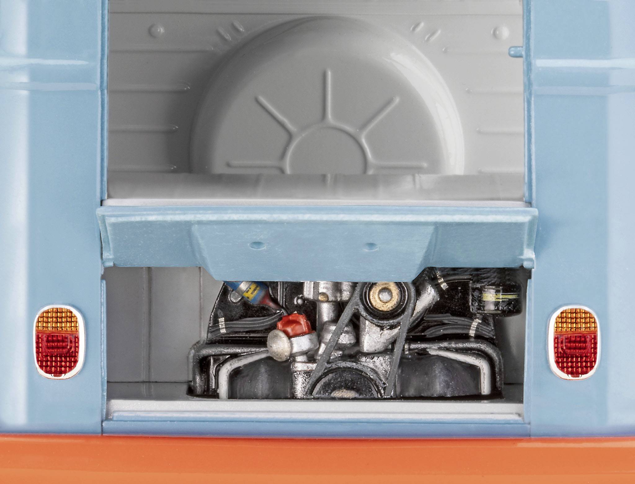 Ein geöffneter Kofferraum eines klassischen Kleinbusses zeigt den Motor. Die blauen und orangefarbenen Teile des Autos sind sichtbar.