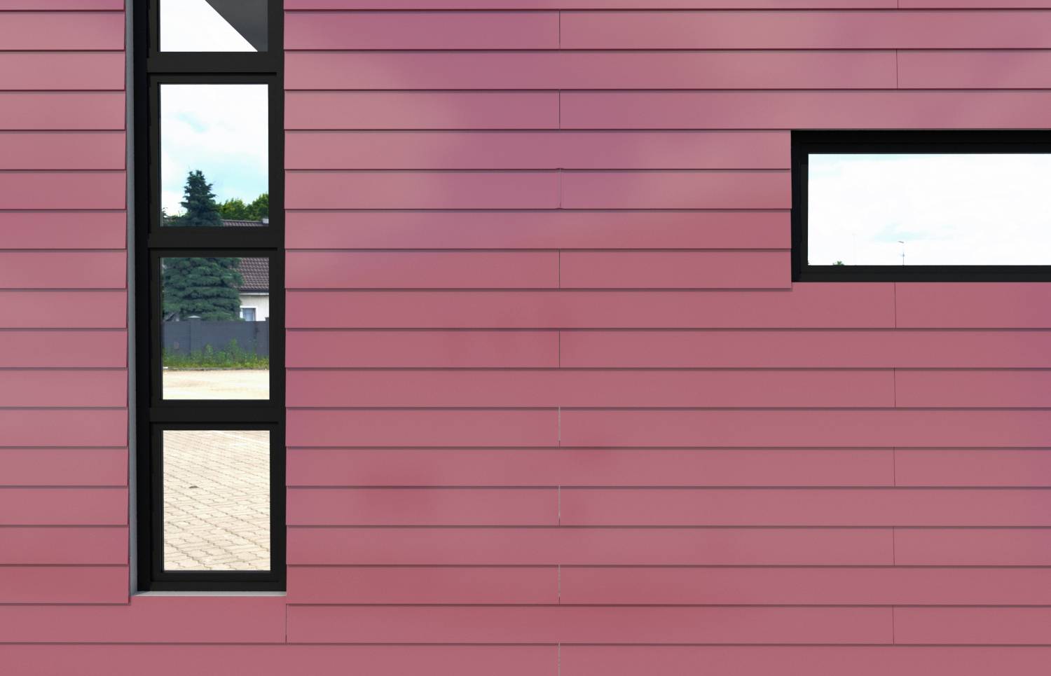 Rosa Fassade mit zwei schmalen, vertikalen Fenstern links und einem horizontalen Fenster rechts, moderner Baustil erkennbar.