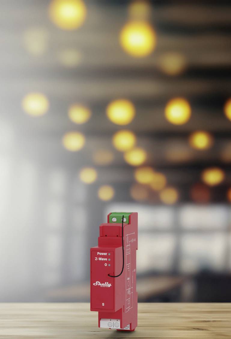 Ein rotes Smart-Home-Gerät steht vor einem unscharfen Hintergrund mit gelbem Licht. Es zeigt 'Power' und 'Z-Wave' an.