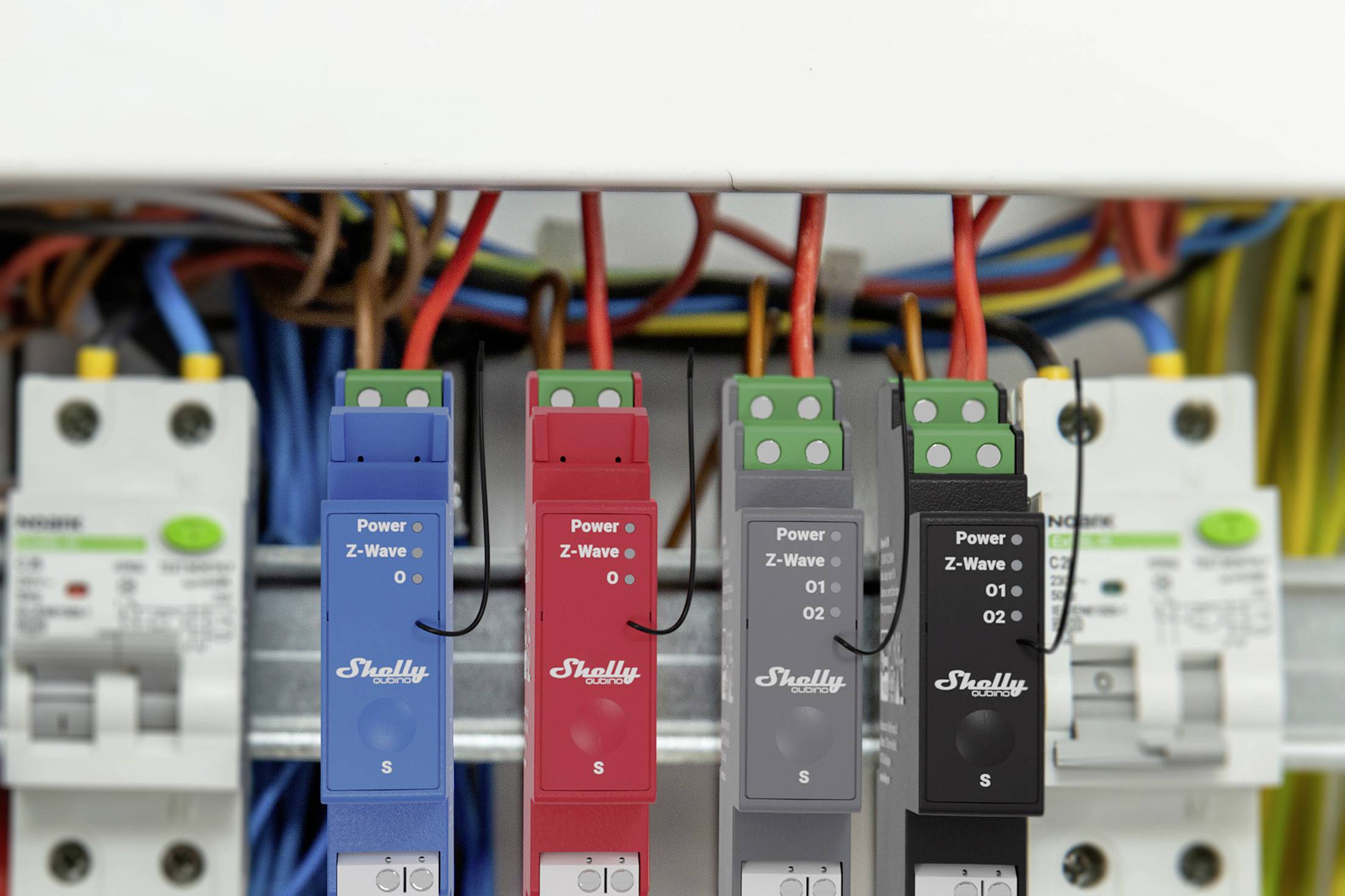 Vier montierte Fernsteuerungskompaktgeräte mit bunten Drähten in einem elektrischen Schaltschrank, bereit zur Konfiguration.