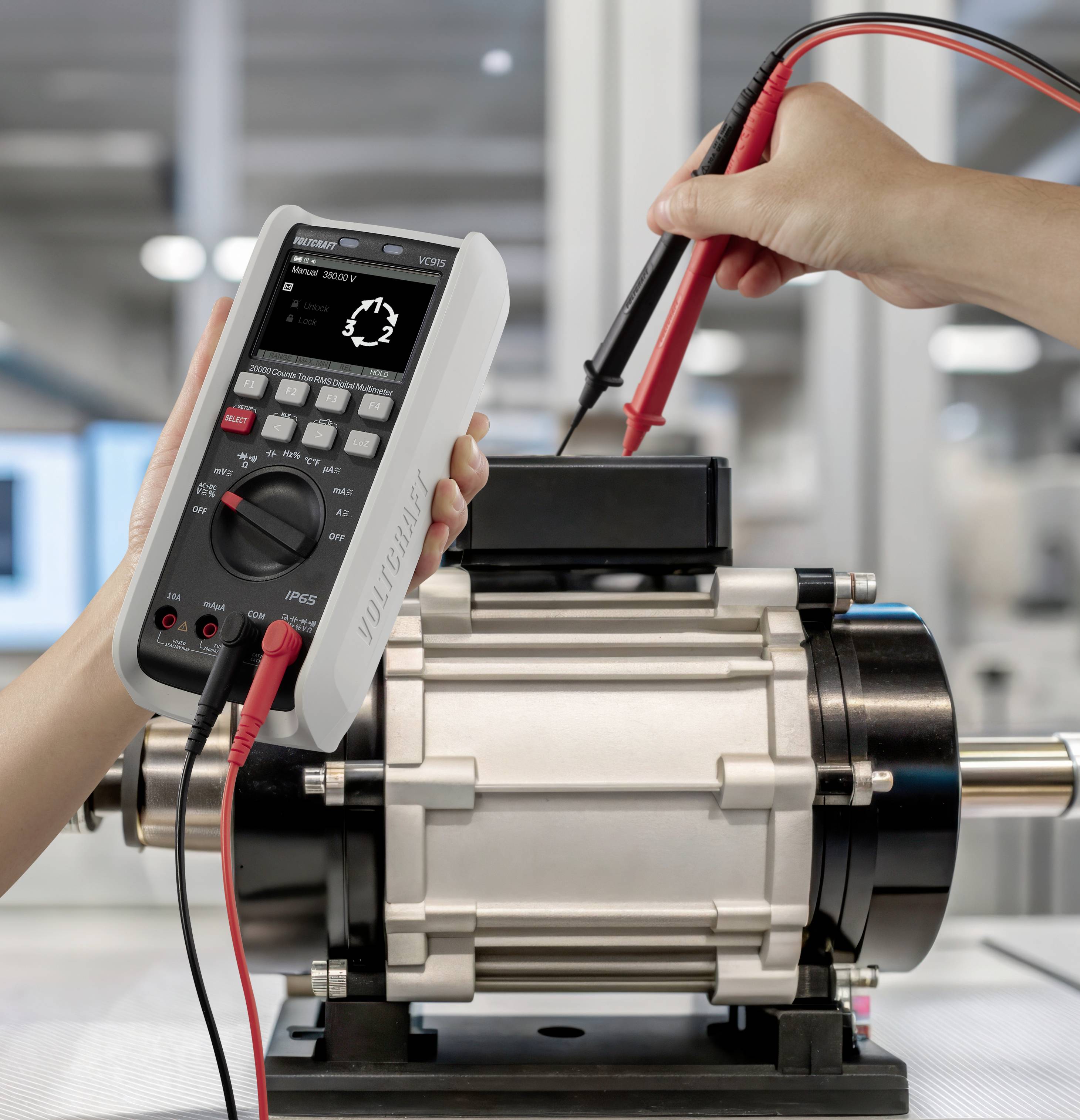 Eine Person verwendet ein Multimeter, um elektrische Werte an einem Industriemotor in einem Laborumfeld zu messen.
