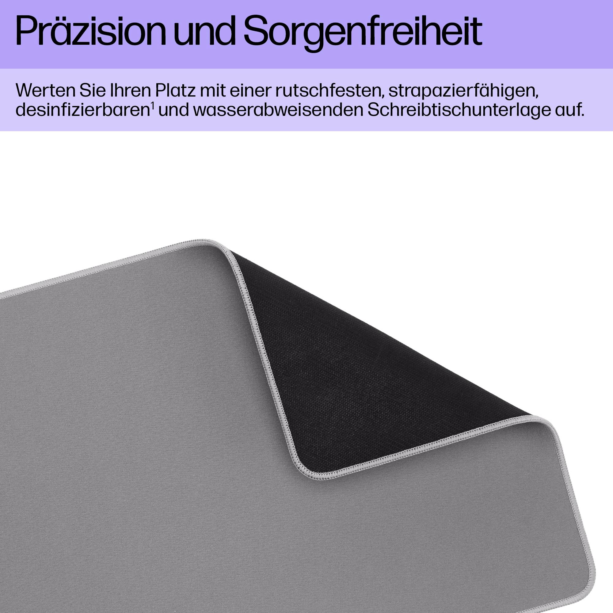 Eine graue Schreibtischunterlage mit schwarzer Rückseite, die rutschfest und wasserabweisend ist, liegt leicht aufgerollt da.