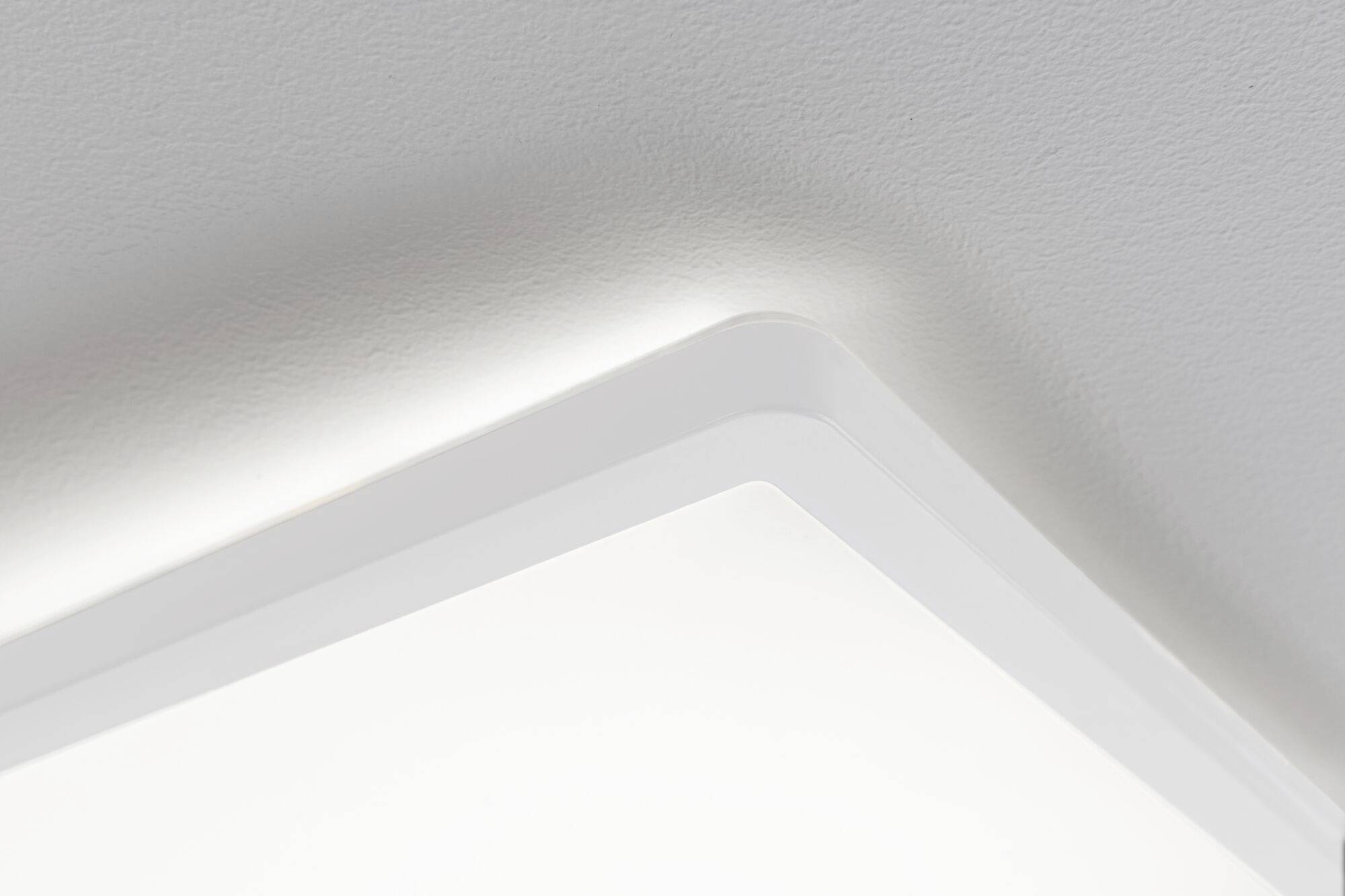 Nahaufnahme einer modernen, rechteckigen Deckenleuchte, die in einem minimalistisch gestalteten Innenraum Licht ausstrahlt.