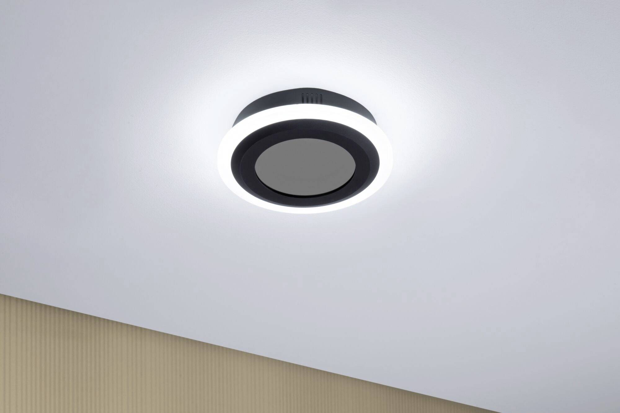 Runde Deckenleuchte mit hellem LED-Licht in modernem Design, an einer weißen Decke montiert.