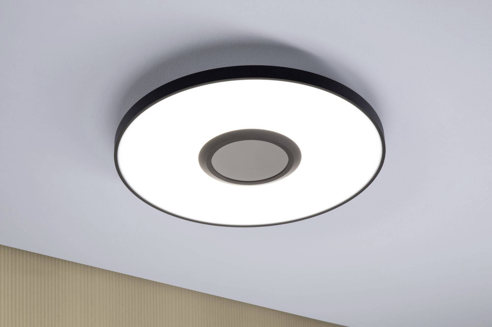 Runde, moderne Deckenleuchte mit LED-Beleuchtung, an einer hellen Decke montiert. Die Leuchte strahlt gleichmäßig und hell.