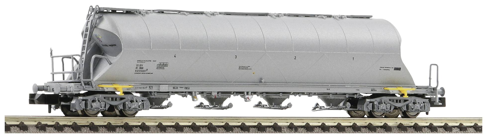 Ein grauer, langgestreckter Güterwaggon auf einem Bahngleis, vermutlich für den Transport von Schüttgut.