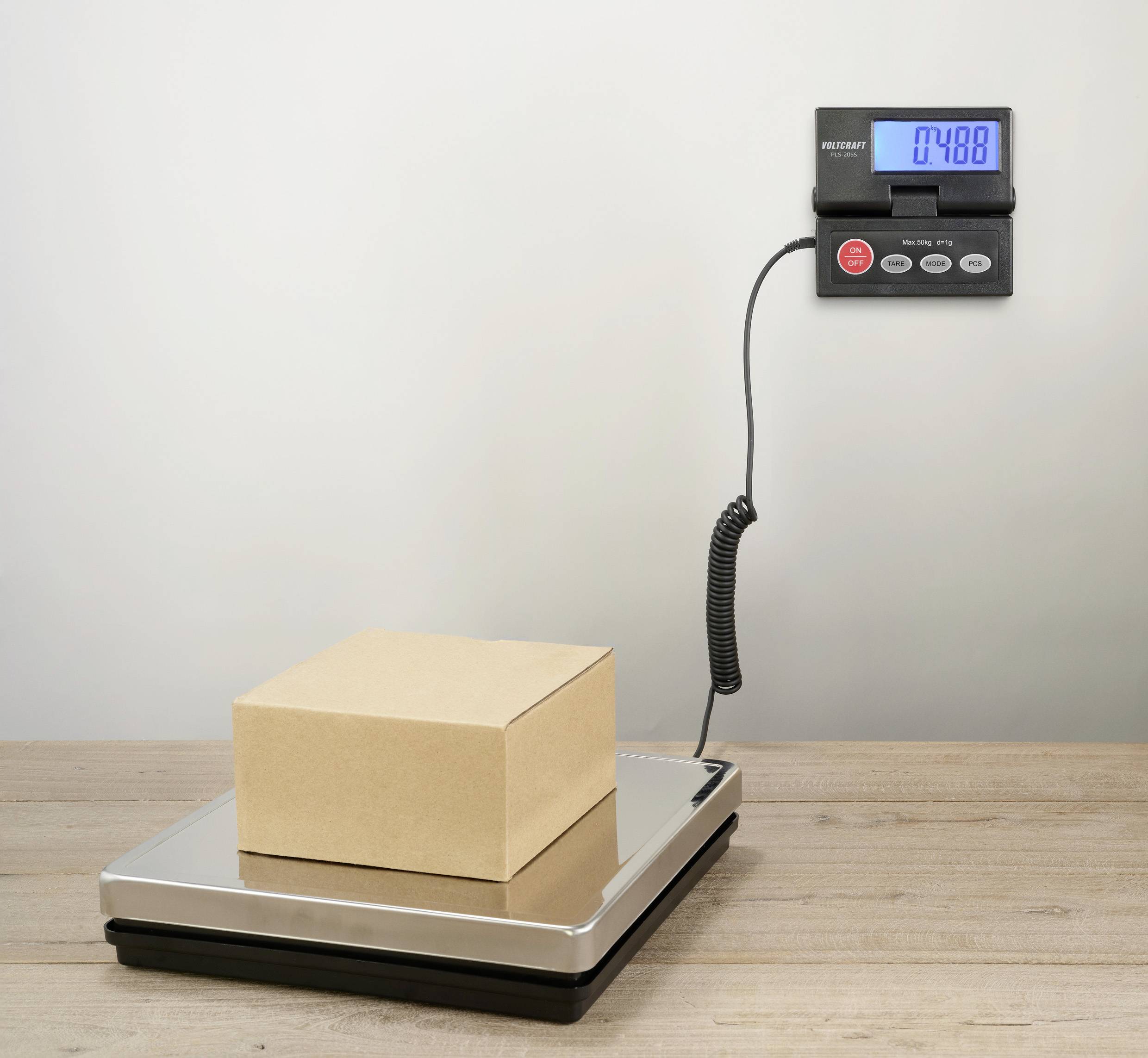 Ein Karton liegt auf einer digitalen Waage, die ein Gewicht von 7,488 kg anzeigt.