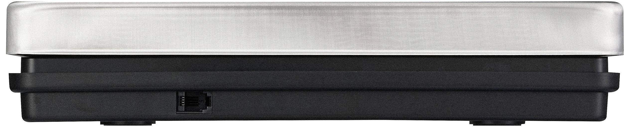 Seitenansicht eines flachen, rechteckigen Geräts mit metallischer Oberseite und schwarzer Basis. Enthält eine kleine Öffnung oder Anschluss an der Seite.