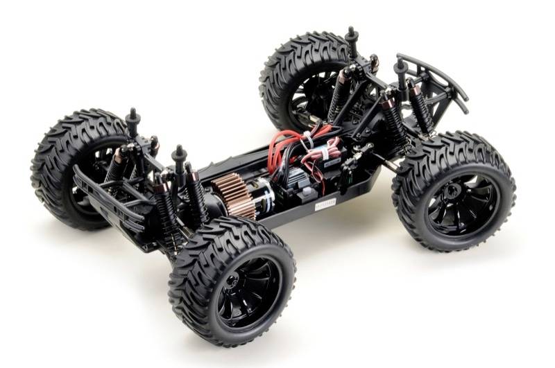 RC-Auto-Chassis mit vier großen Geländereifen, sichtbaren Stoßdämpfern und verkabeltem Elektromotor.