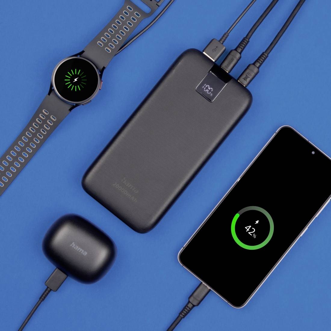 Eine Smartwatch, ein tragbarer Akku, ein Smartphone mit 42 % Ladung und kabellose Ohrhörer auf blauem Hintergrund zeigen Ladesituation.