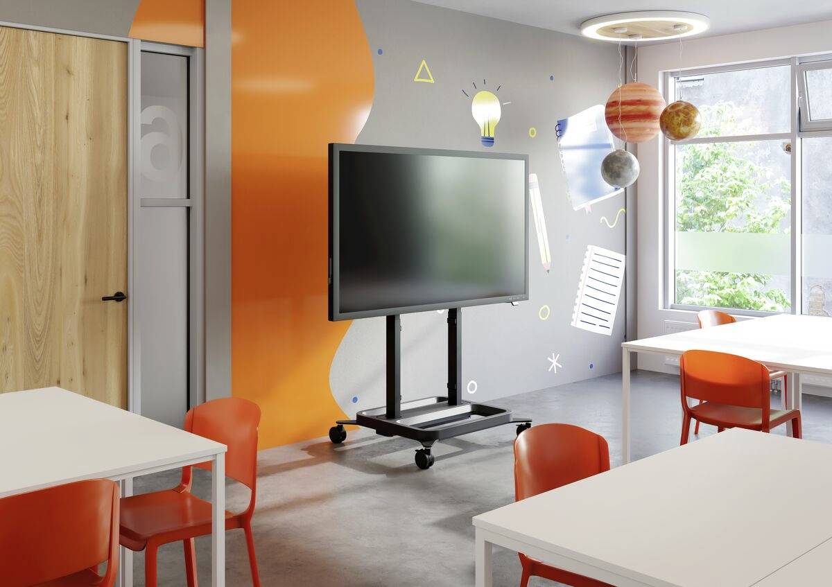 Ein moderner Klassenraum mit interaktiver Tafel, orangen Stühlen und kreativen Wanddekorationen, darunter bunte Planeten und eine Glühbirne.