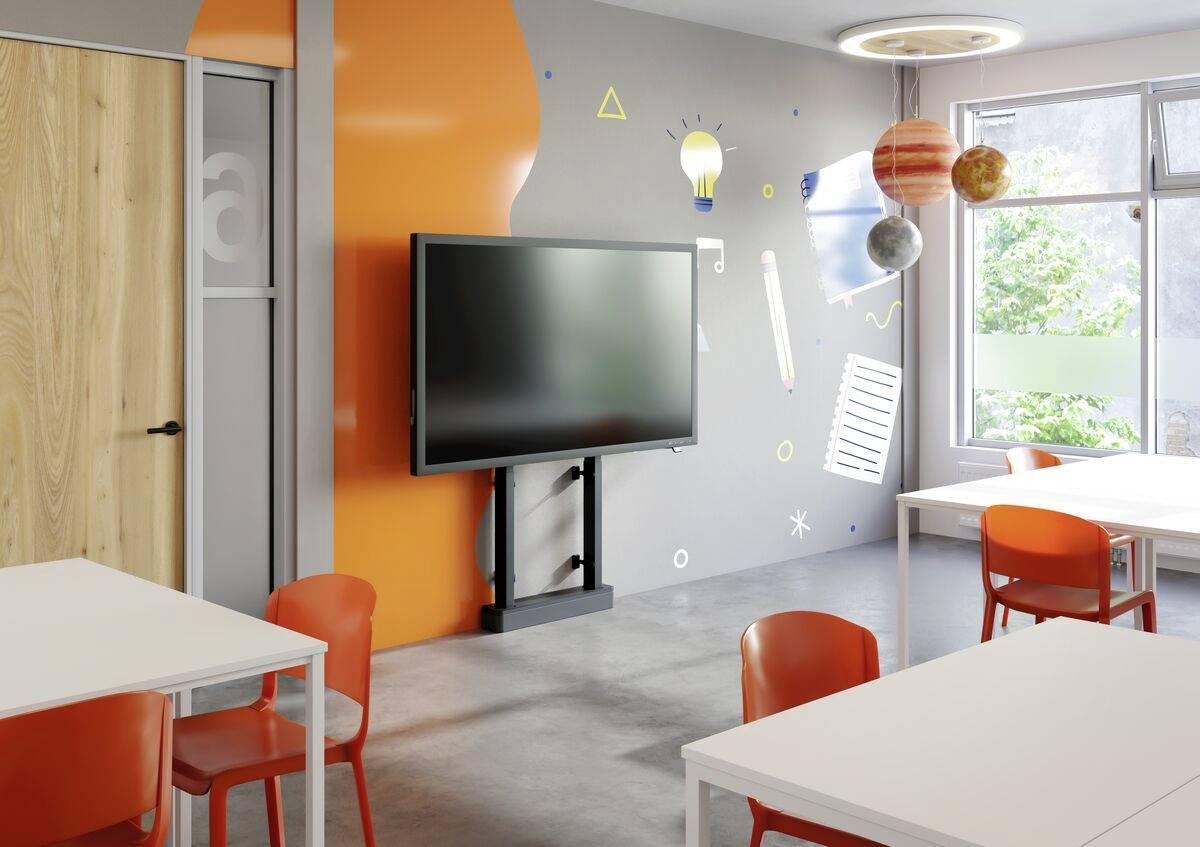 Klassenzimmer mit bunten Wänden, interaktivem Bildschirm und orangen Stühlen. An der Wand sind Bildungssymbole und Planeten abgebildet.